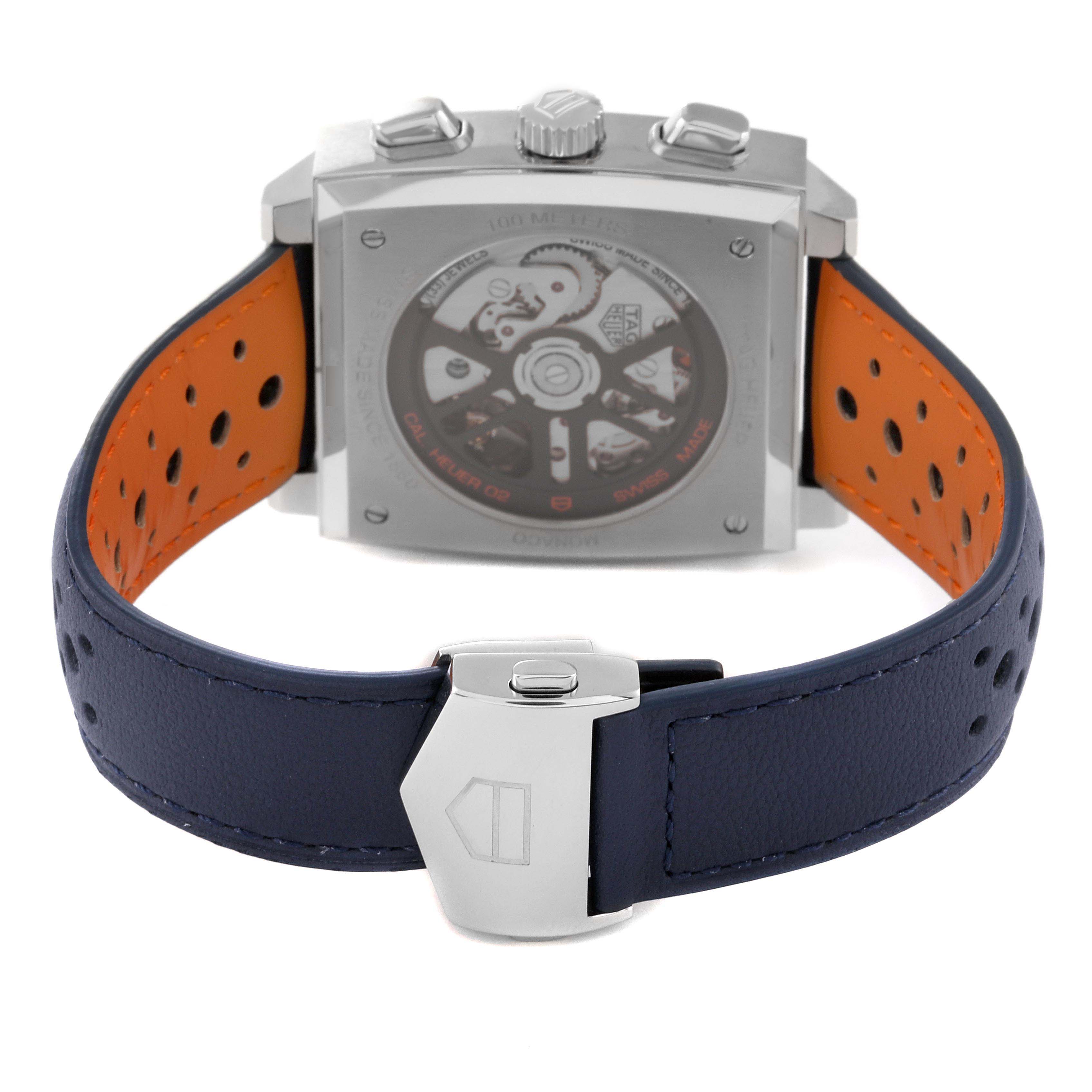 The image shows the back view of a Tag Heuer Monaco CBL2115.FC6494 Men's Stainless Steel Blue Dial CBL2115.FC6494 Men's Stainless Steel Blue Dial watch, highlighting its inner mechanisms and leather strap with a clasp.