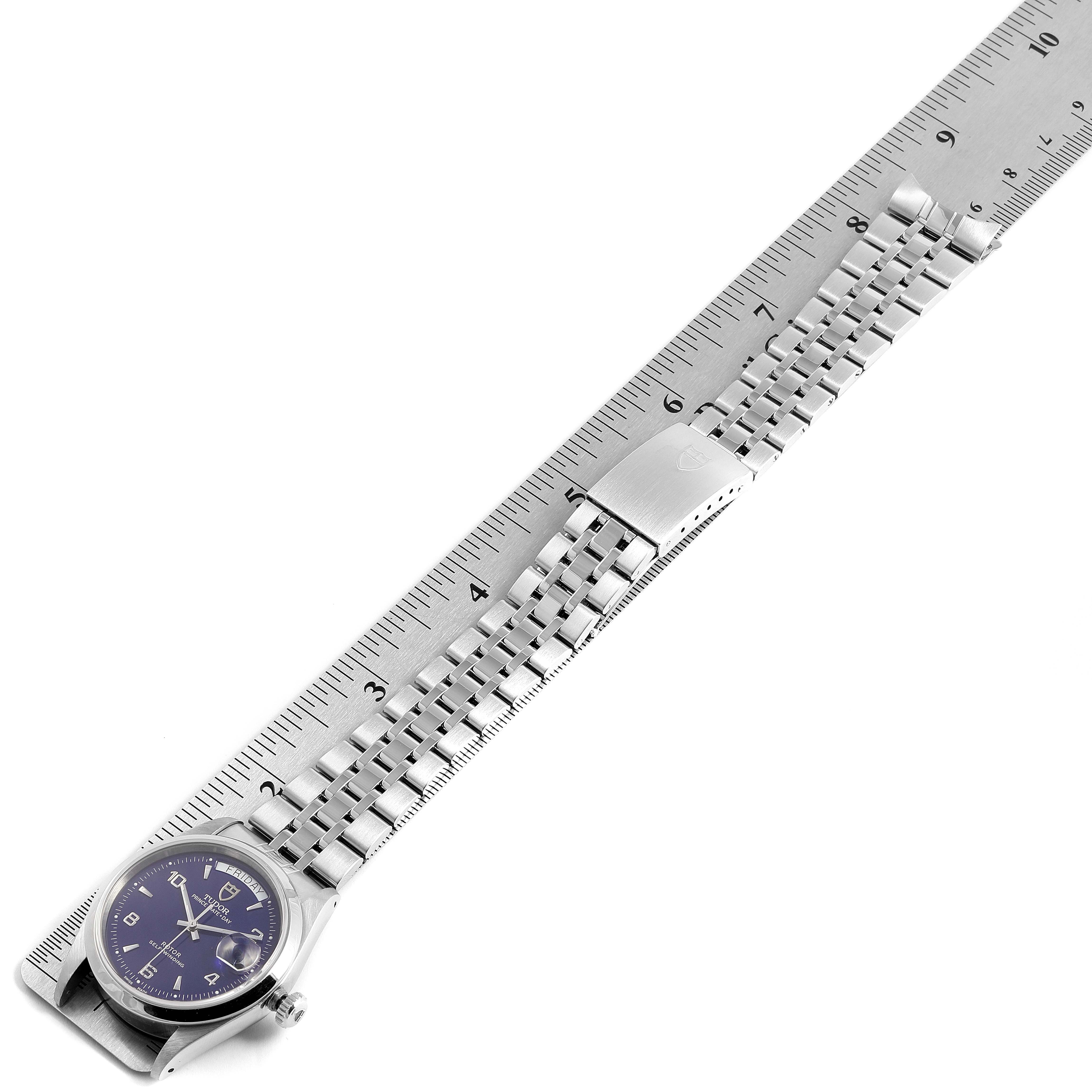 The image shows a side view of the Tudor Glamour 76200 Men's Stainless Steel Blue Dial 76200 Men's Stainless Steel Blue Dial watch, including its stainless steel bracelet and clasp, against a ruler for scale.