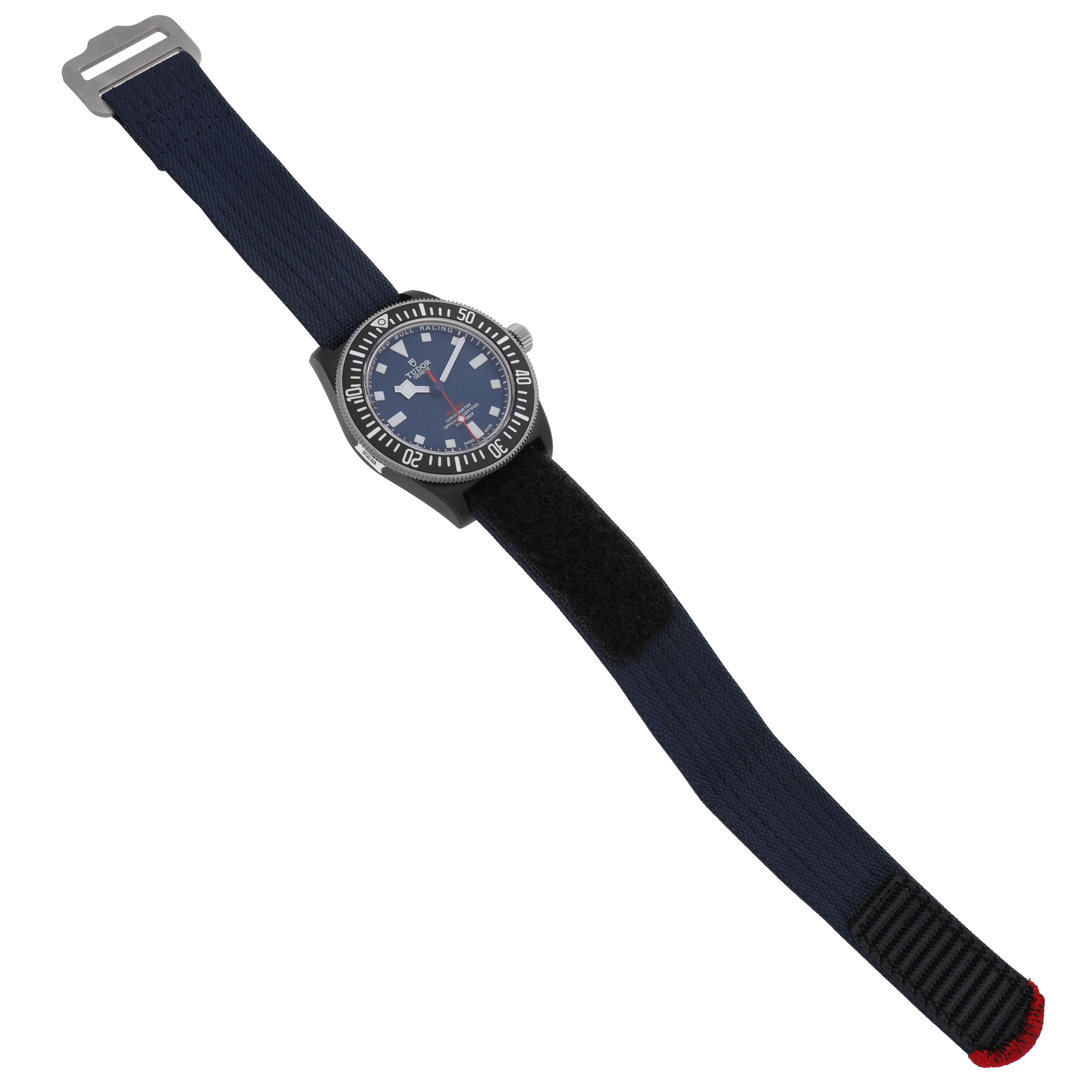 The Tudor Pelagos 25707KN Men's Titanium Blue Dial watch is shown from a top view, displaying the face and blue fabric strap with a Velcro section.