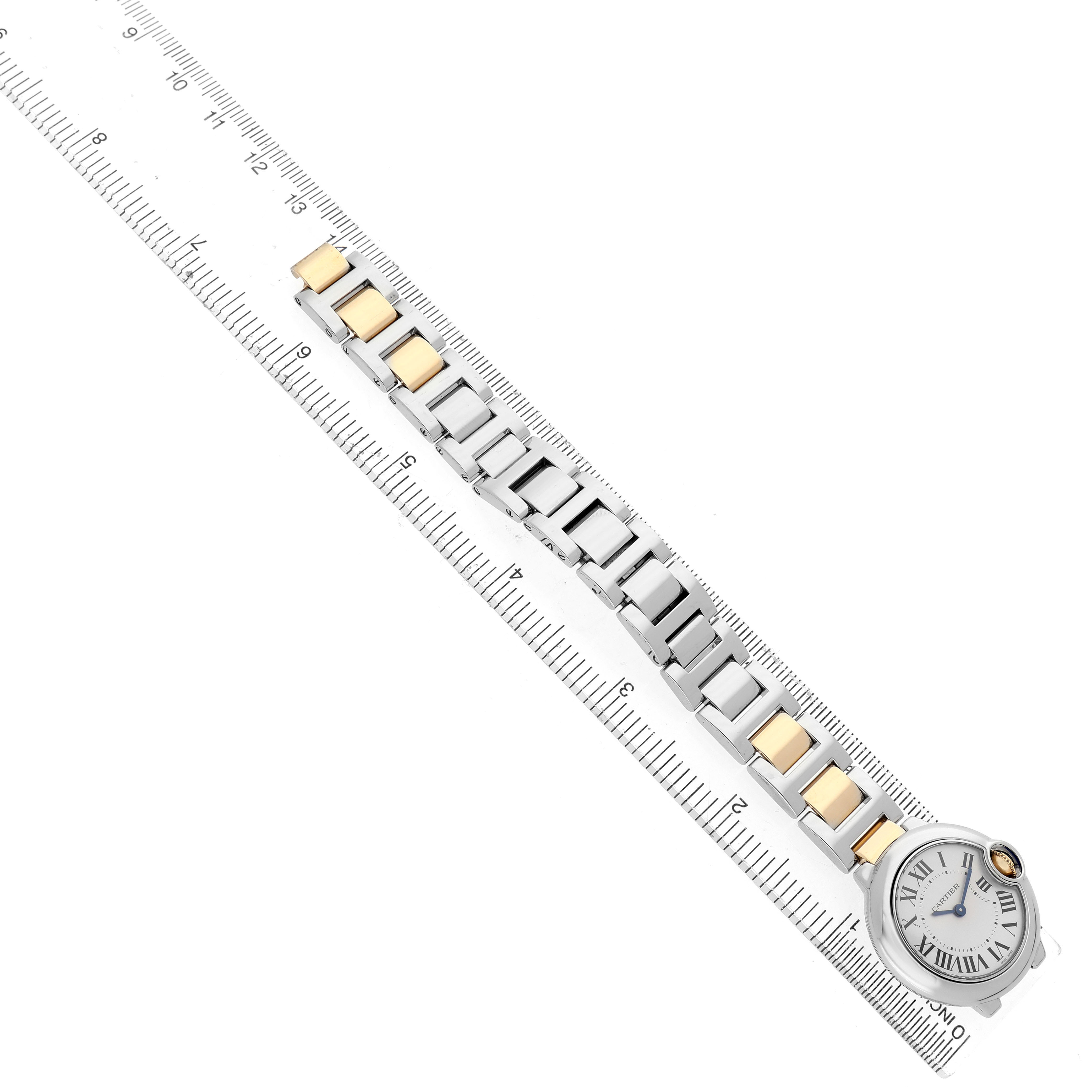 The Cartier Ballon Bleu W69007Z3 Women's Steel and Gold (two tone) Silver Dial watch is shown from an overhead angle, highlighting its band and face alongside a ruler for scale.