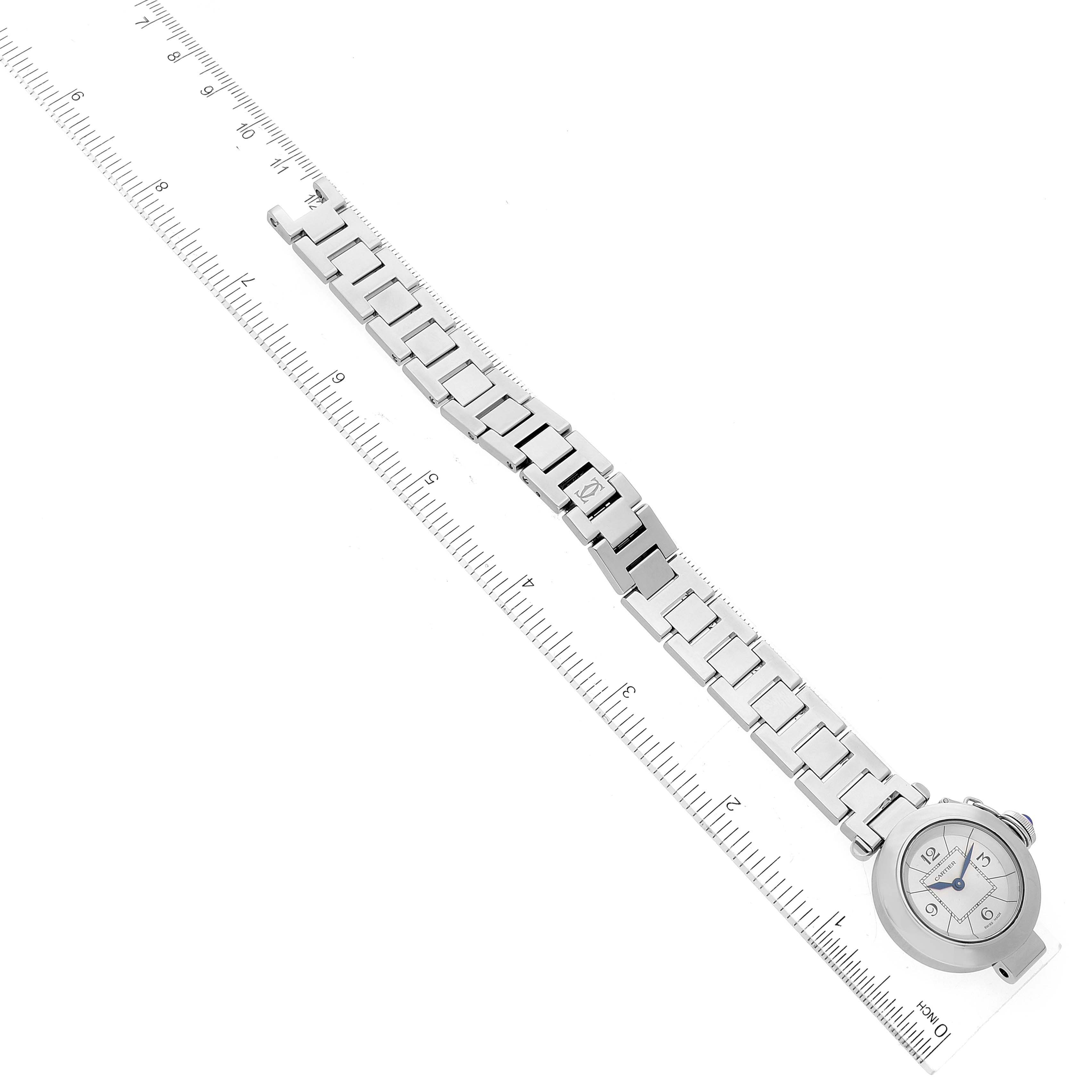 The image shows a top view of a Cartier Pasha W3140007 Women
s Stainless Steel Silver Dial W3140007 Women
s Stainless Steel Silver Dial watch, displaying the face, bezel, and metal bracelet on a measurement grid.