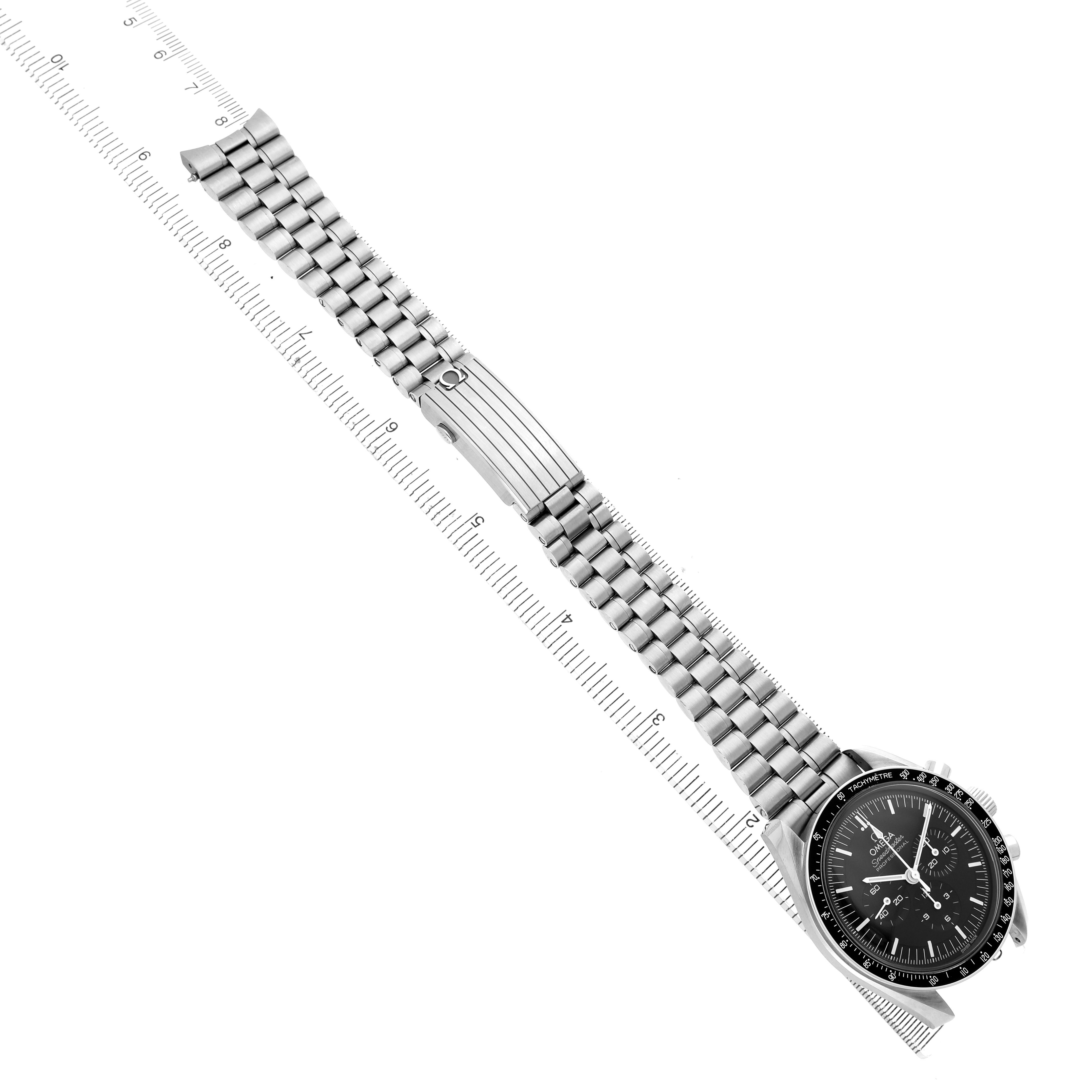 The Omega Speedmaster 310.30.42.50.01.001 Men's Stainless Steel Black Dial is shown from a top-down angle, highlighting the entire watch and bracelet against a ruler backdrop.