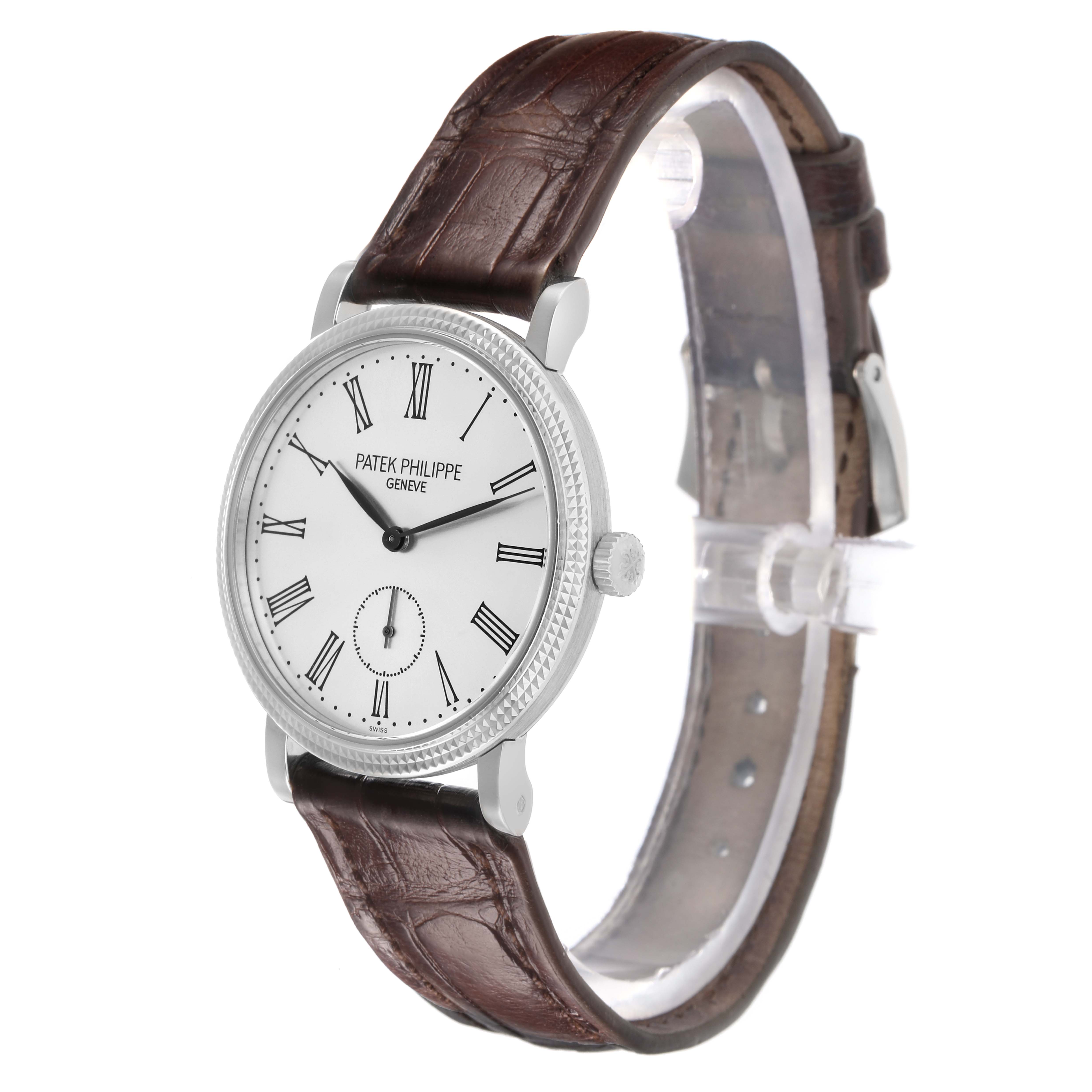 The Patek Philippe Calatrava 7119G Women
s White Gold White Dial is shown at an angled side view, displaying its face, crown, and leather strap.