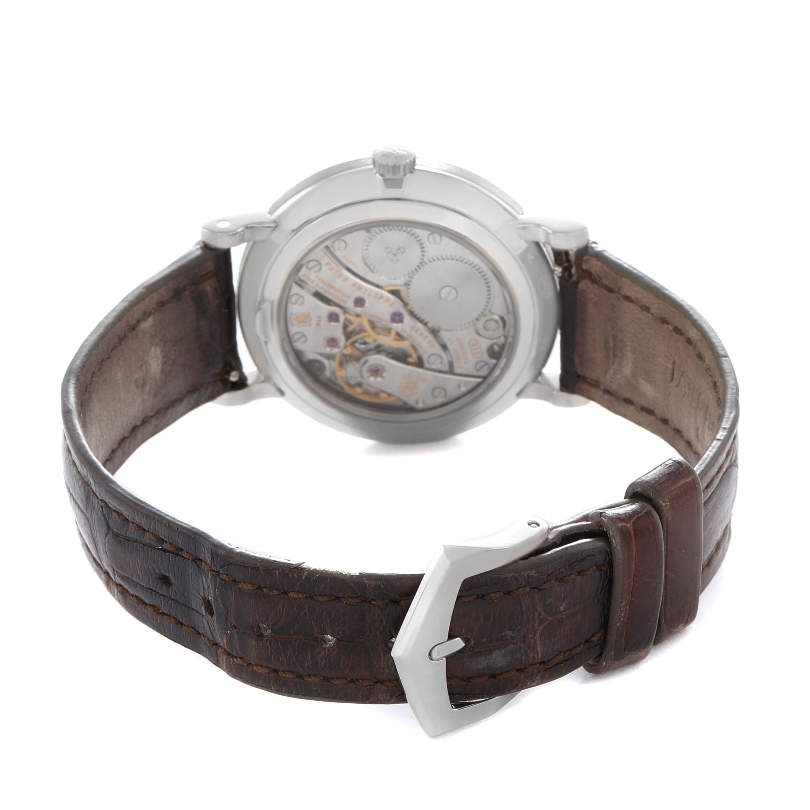 The image shows the rear view of a Patek Philippe Calatrava 7119G Women
s White Gold White Dial, highlighting its mechanical movement and leather strap.