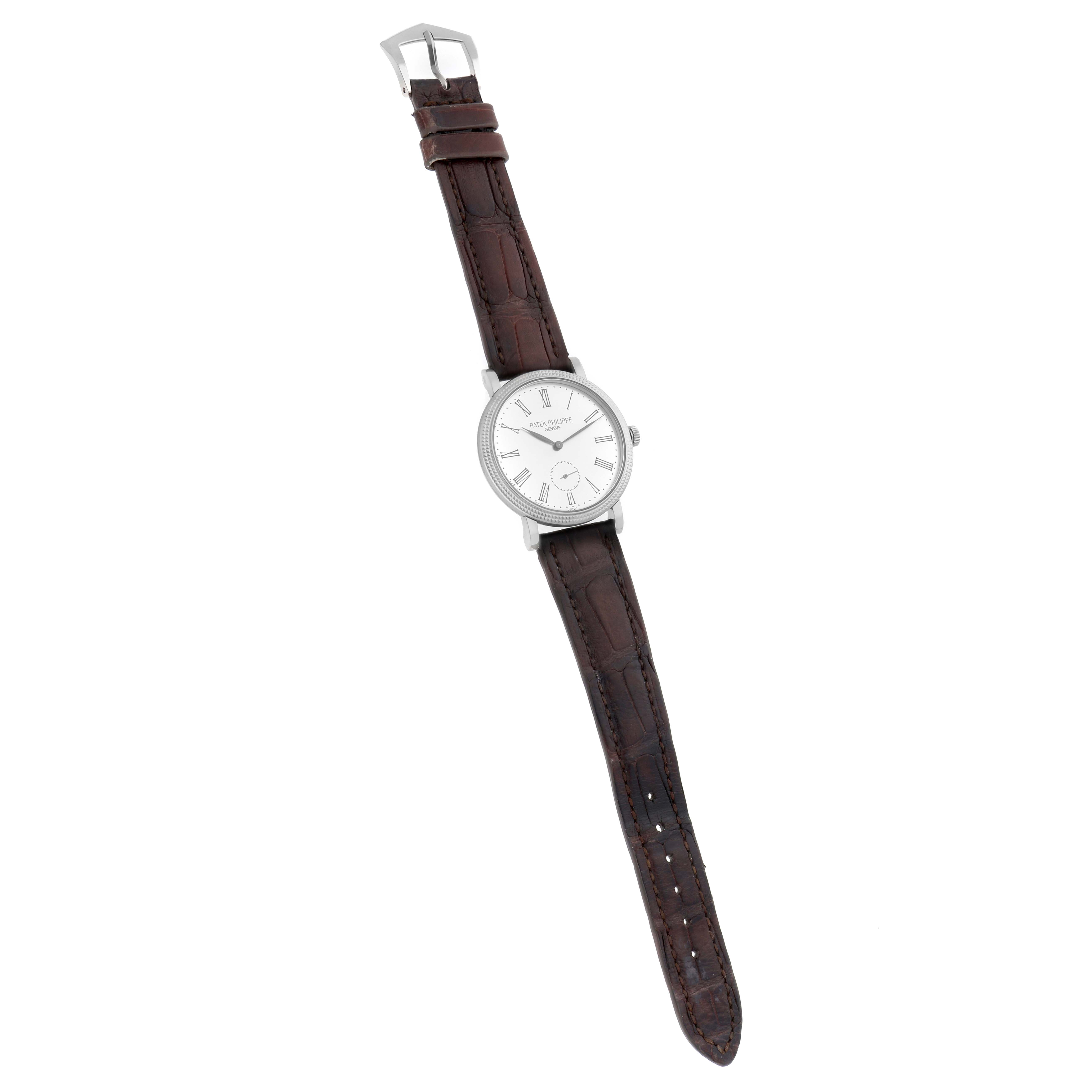 The Patek Philippe Calatrava 7119G Women
s White Gold White Dial watch is shown from a slightly angled top view, displaying the face, bezel, and brown leather strap.