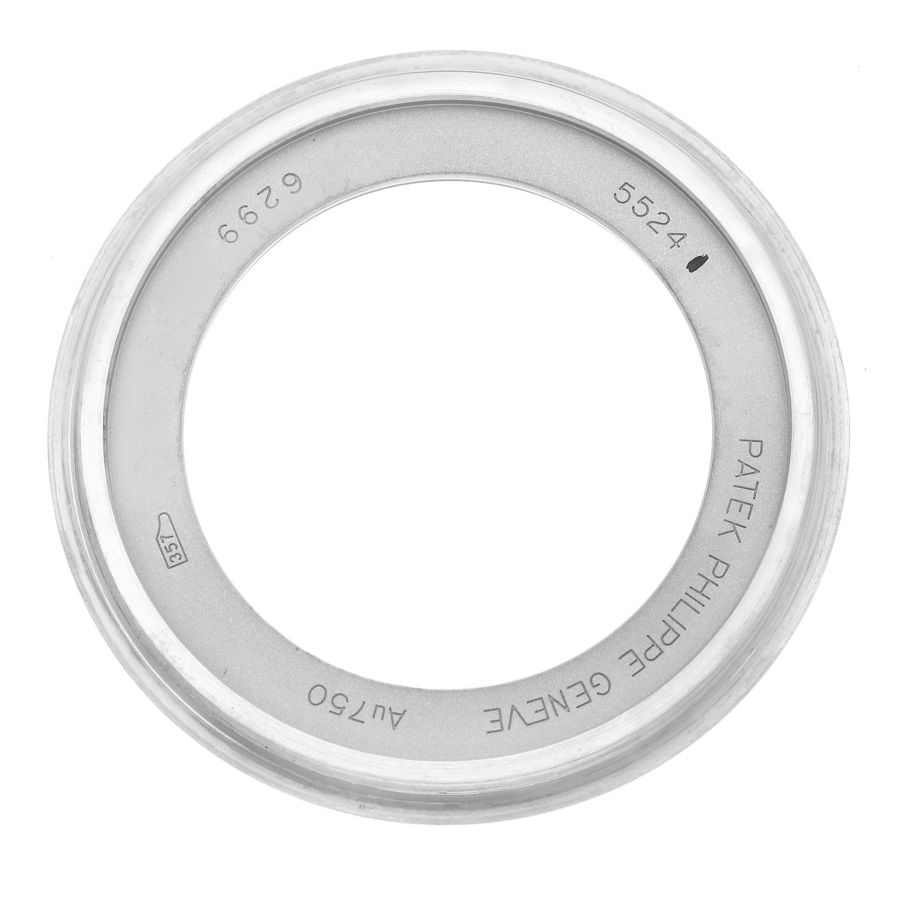 The image shows a Patek Philippe Calatrava 5524G-001 Men
s White Gold Blue Dial model
s bezel ring viewed from above, featuring engravings and a smooth metal finish.