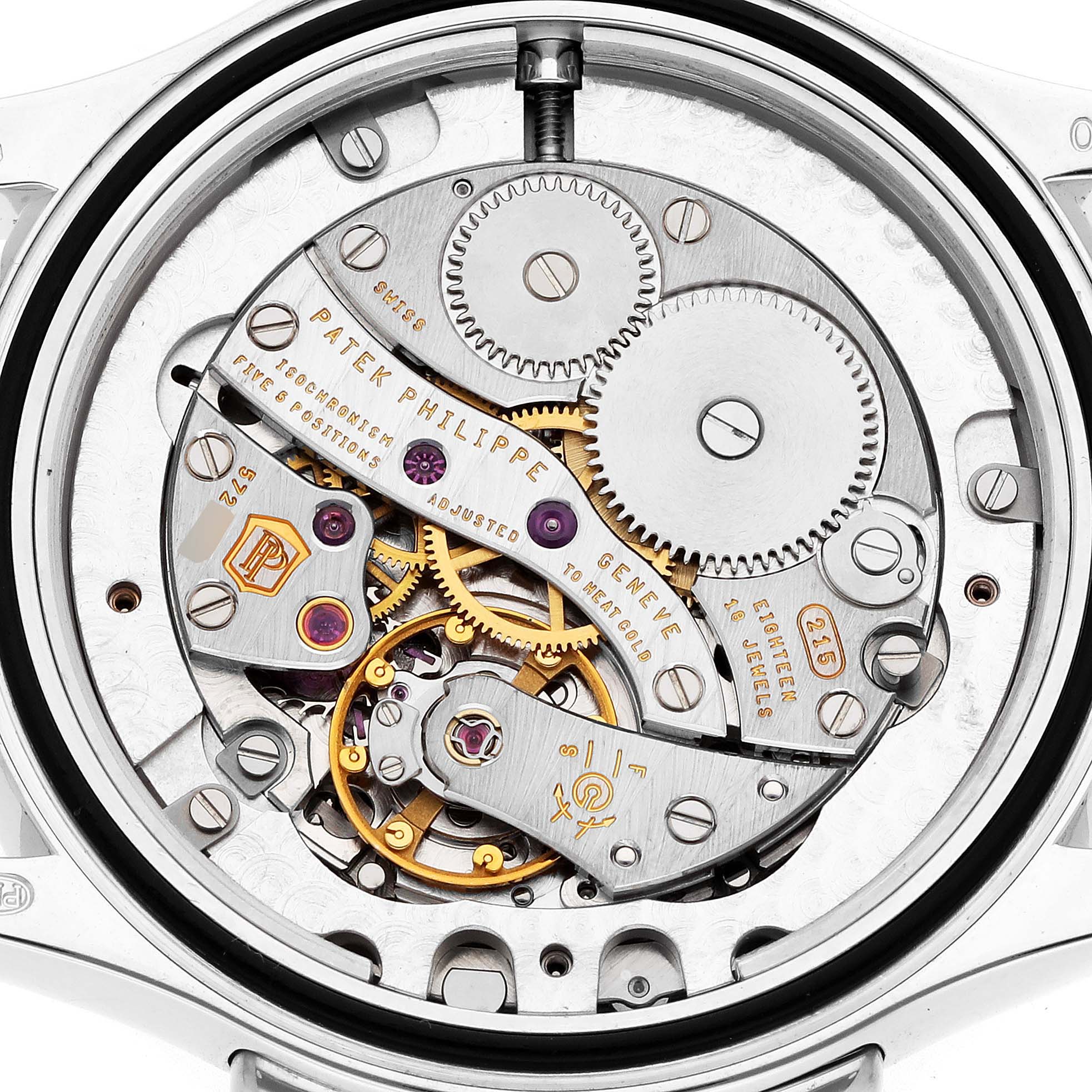 The image shows the intricate movement of a Patek Philippe Calatrava 4934G-001 Women
s White Gold Mother of Pearl Dial watch from a rear view, highlighting the gears and components.