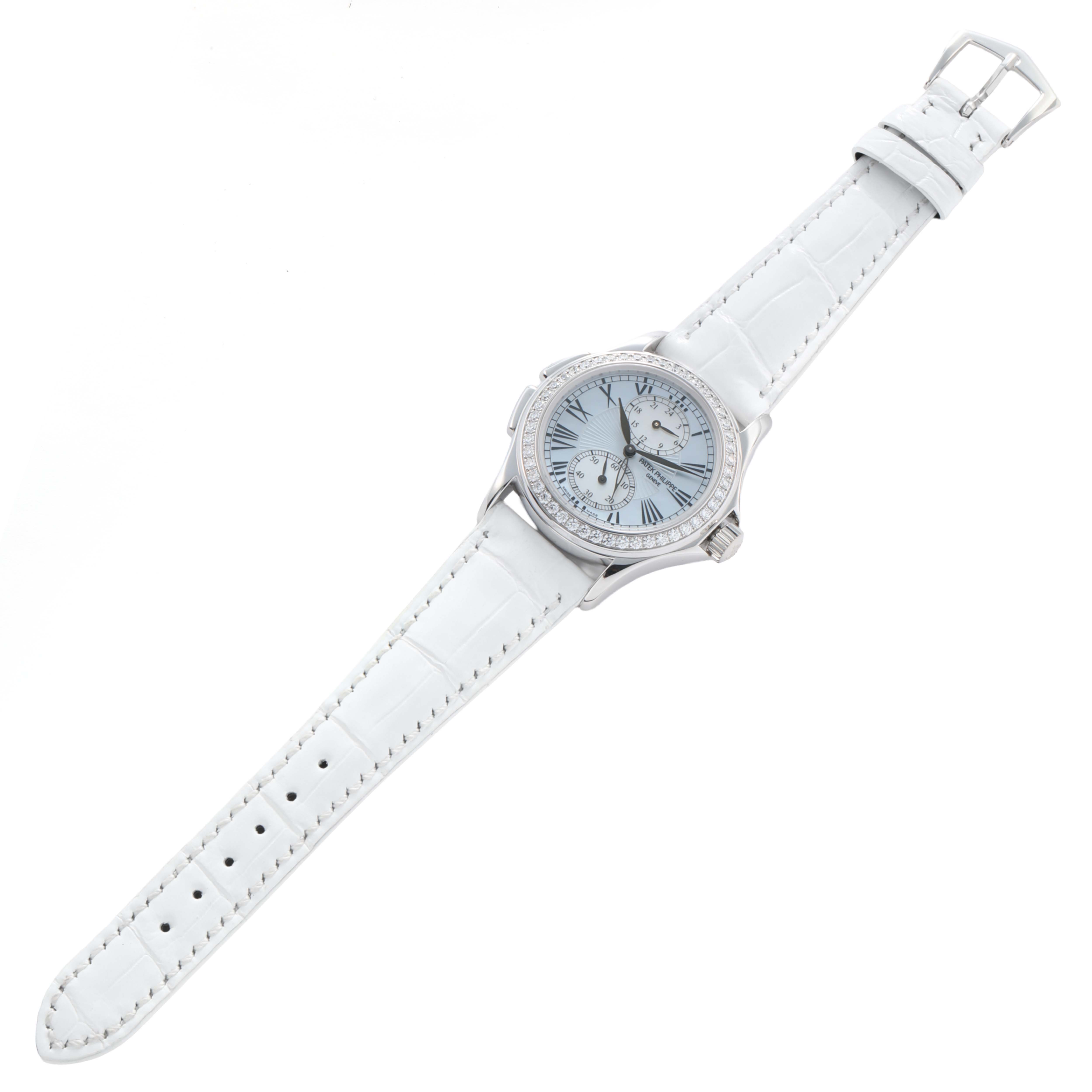 This Patek Philippe Calatrava 4934G-001 Women
s White Gold Mother of Pearl Dial watch is shown at a top-down angle, featuring its face, case, strap, and buckle.