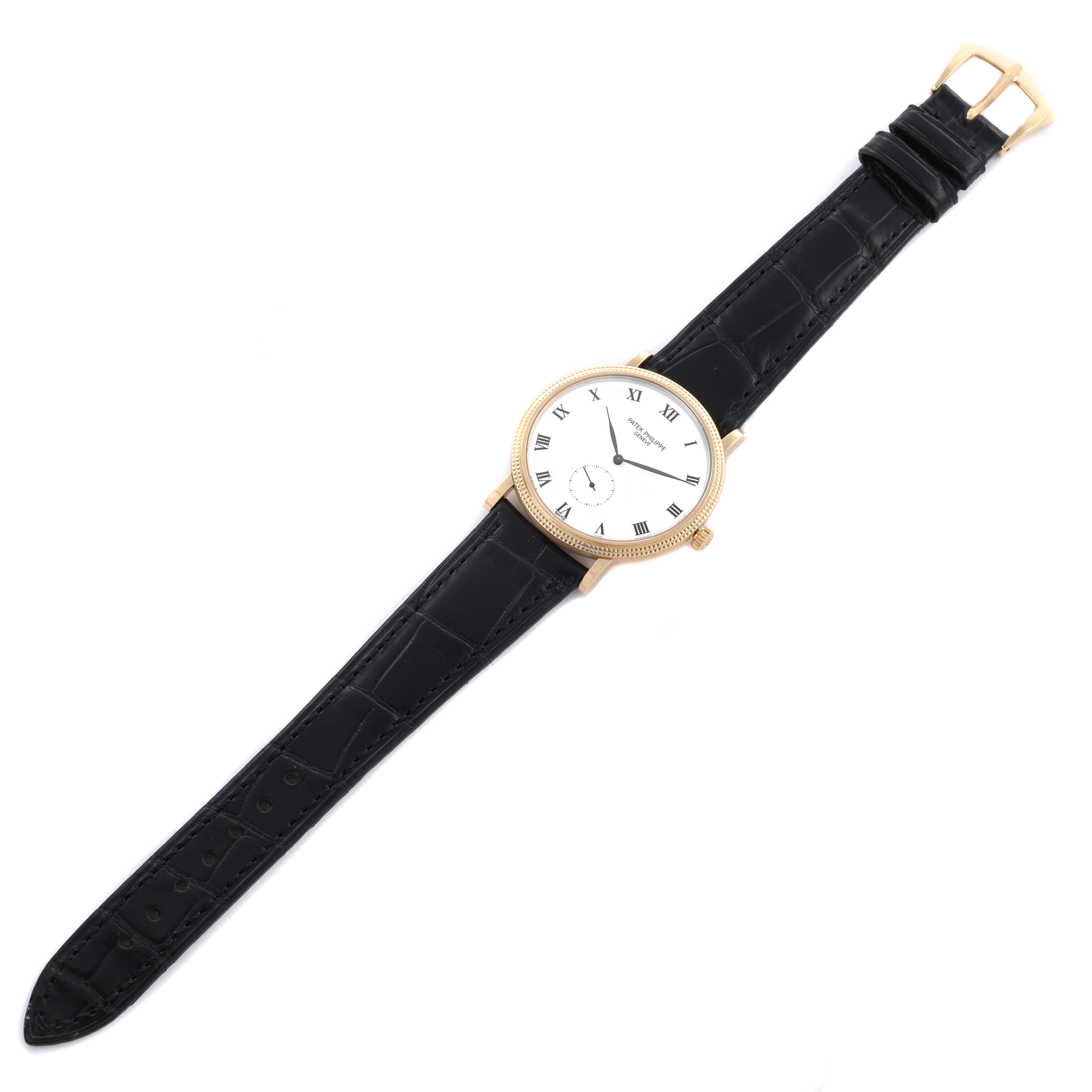 The Patek Philippe Calatrava 3919J Men's Yellow Gold White Dial 3919J Men's Yellow Gold White Dial watch is shown from a top-down angle, featuring its full face and black leather strap.