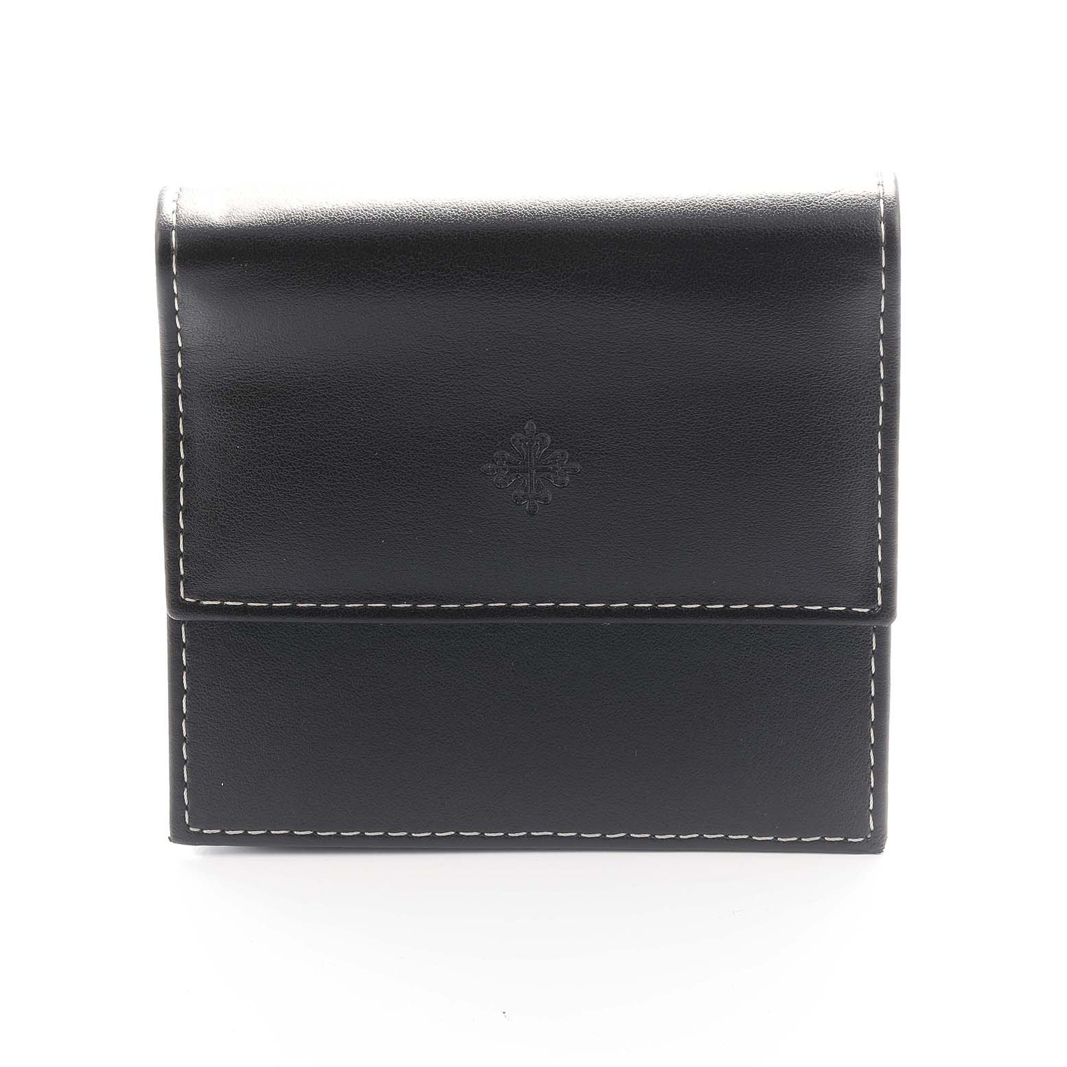 This image shows a straight-on view of a Patek Philippe Twenty-4 4908G Women
s White Gold Silver Dial watch
s black leather case with white stitching.