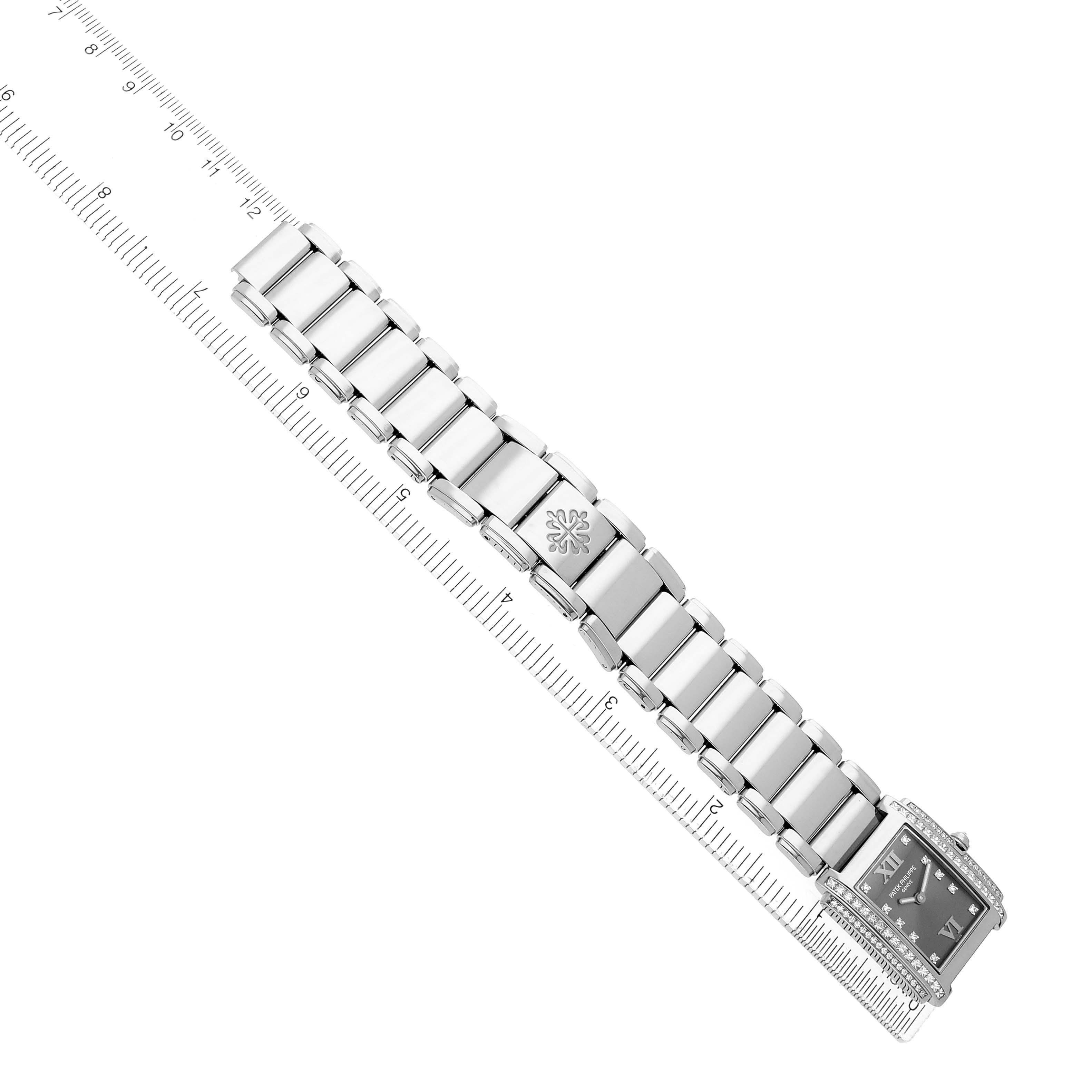 The Patek Philippe Twenty-4 4910/20G-001 Women's White Gold Silver Dial watch is shown from an overhead angle, highlighting the bracelet and face with a ruler beside it.