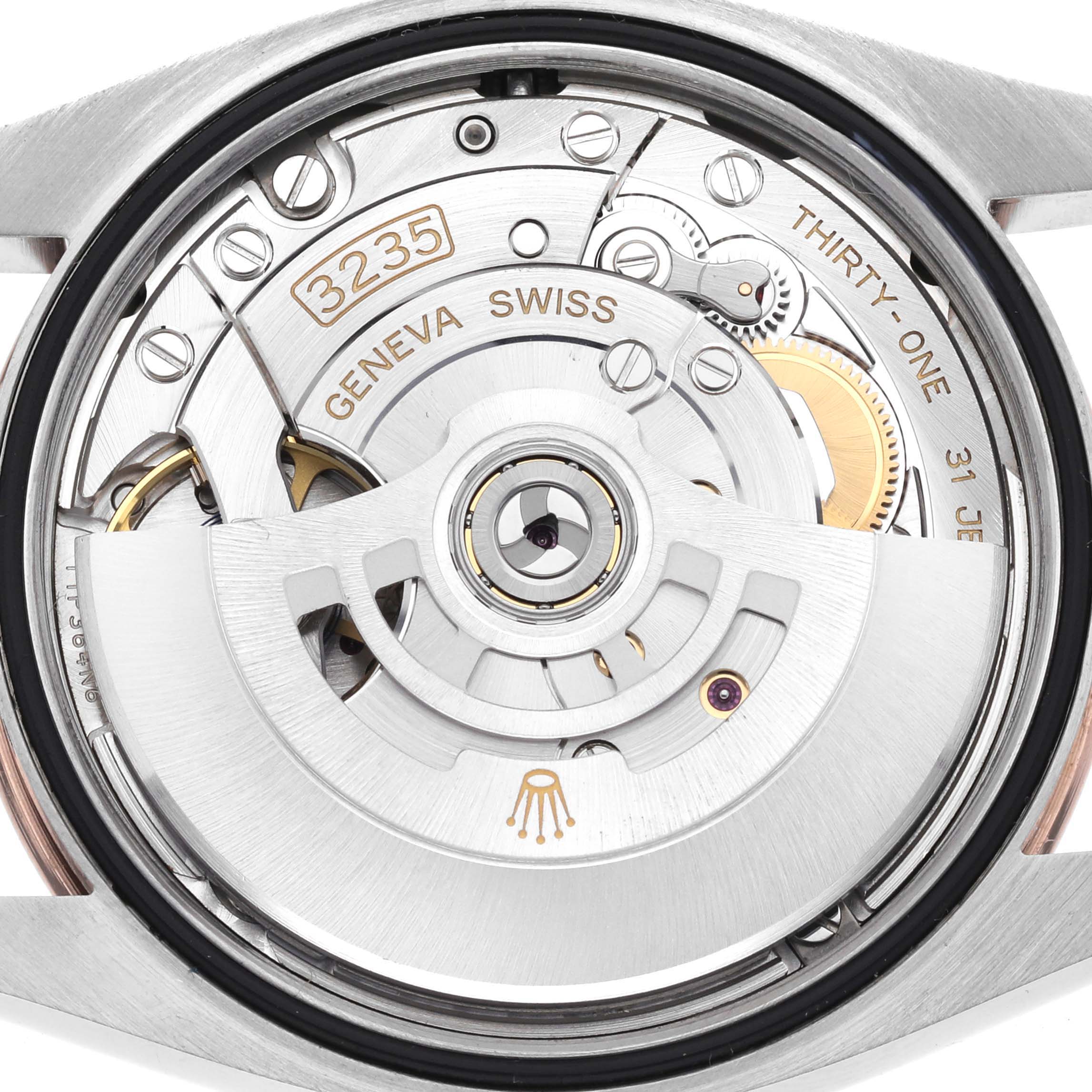 The image shows the back of the Rolex Datejust 126201 Men's Steel and Gold (two tone) White Dial 126201 Men's Steel and Gold (two tone) White Dial watch, revealing its intricate movement and the rotor mechanism.