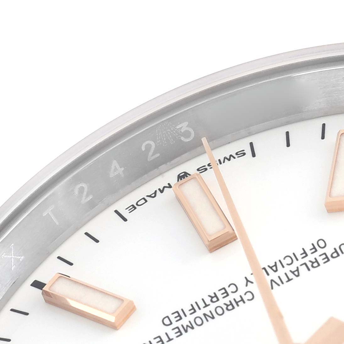 The image shows a partial close-up of the Rolex Datejust 126201 Men's Steel and Gold (two tone) White Dial 126201 Men's Steel and Gold (two tone) White Dial's bezel, dial, and indices from an angled top view.