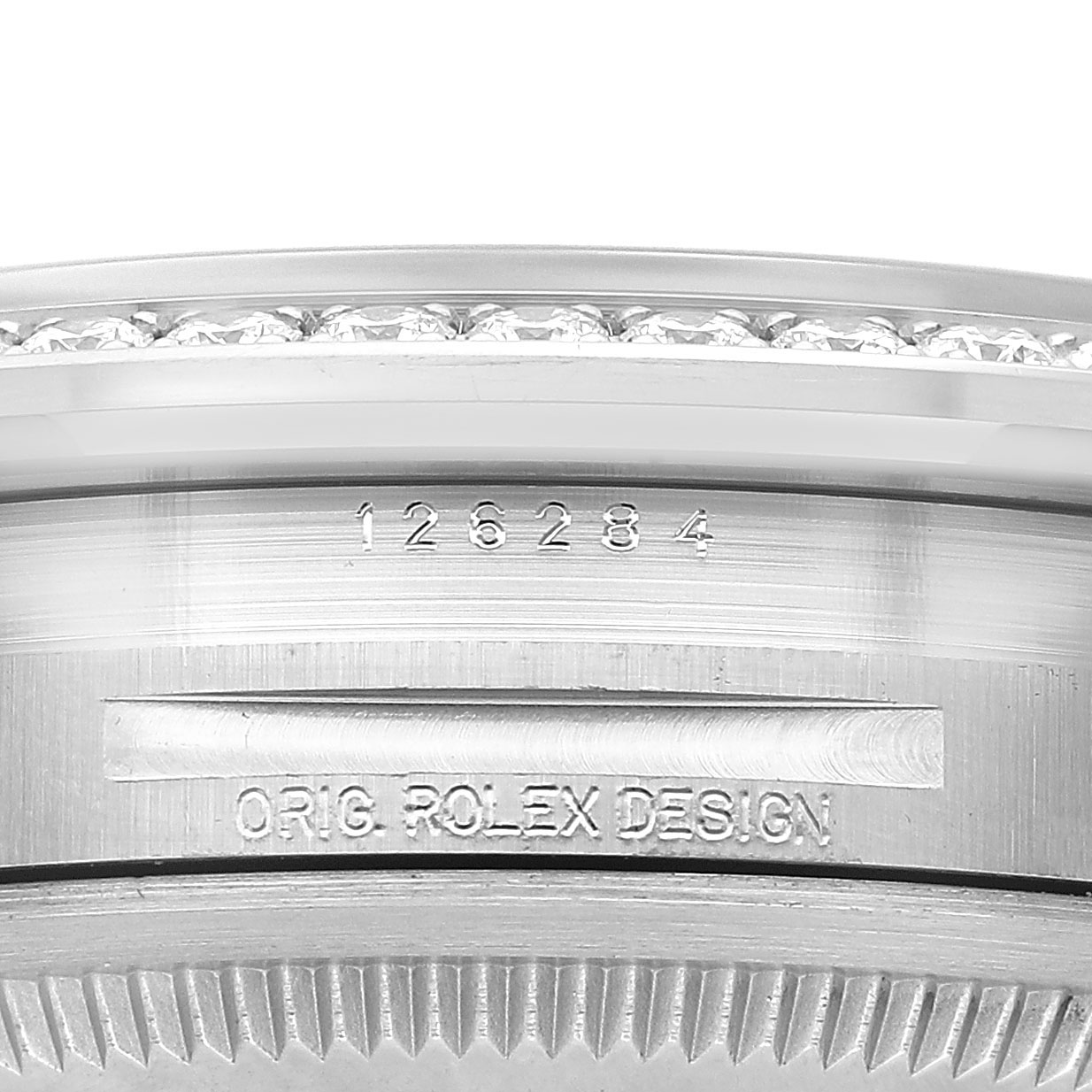 The image shows a close-up of the side of a Rolex Datejust 126284RBR Men's Stainless Steel Purple Dial watch case, detailing the serial number and "ORIG. ROLEX DESIGN" engraving.