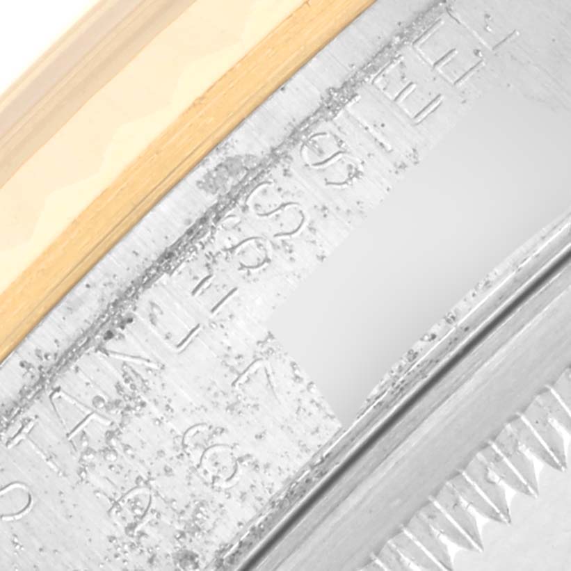 The image shows a close-up of the side of a Rolex Datejust 16233 Men
s Steel and Gold (two tone) Silver Dial 16233 Men
s Steel and Gold (two tone) Silver Dial, highlighting the stainless steel part and some engravings.
