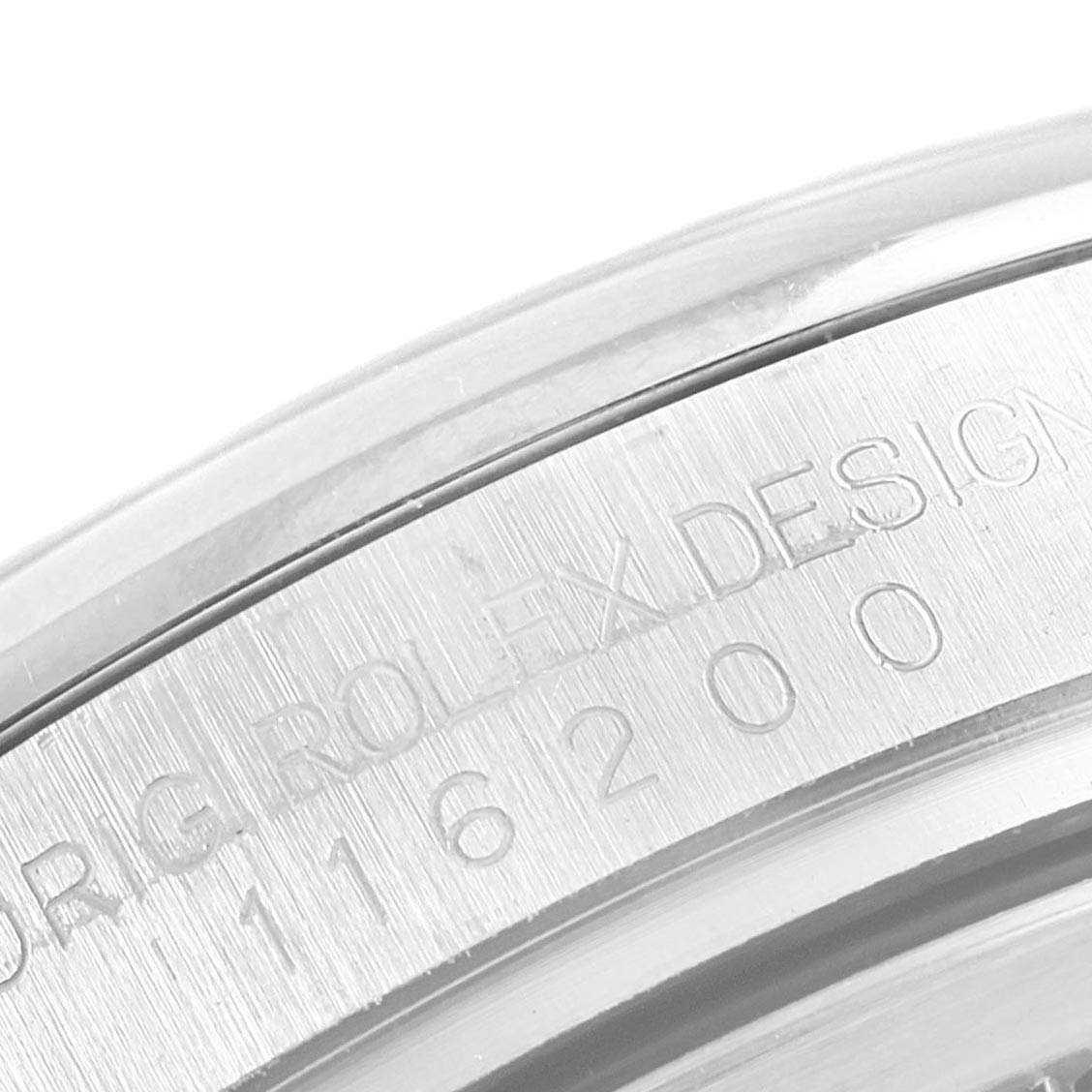The image shows an angled close-up of the bezel and engraved serial number of a Rolex Datejust 116200 Men's Stainless Steel Black Dial 116200 Men's Stainless Steel Black Dial watch.