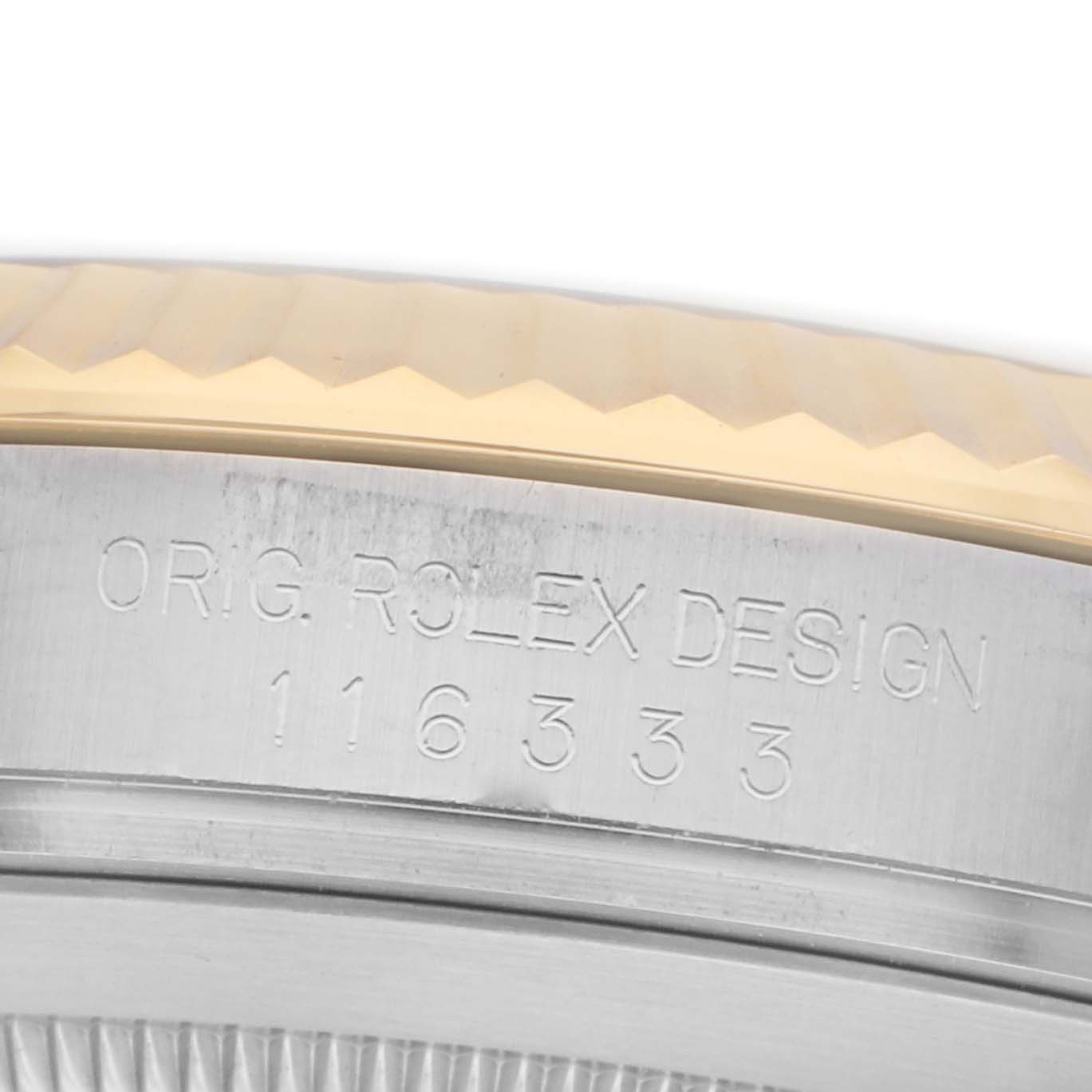 The image shows a partial view of the Rolex Datejust 41 116333 Men
s Steel and Gold (two tone) Champagne Dial
s case side with engraved design details.
