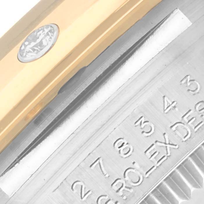 The image shows a close-up of the Rolex Mid-Size 278343RBR-0030 Women's Steel and Gold (two tone) Green Dial 278343RBR-0030 Women's Steel and Gold (two tone) Green Dial case edge with engravings and a diamond detail on the bezel.