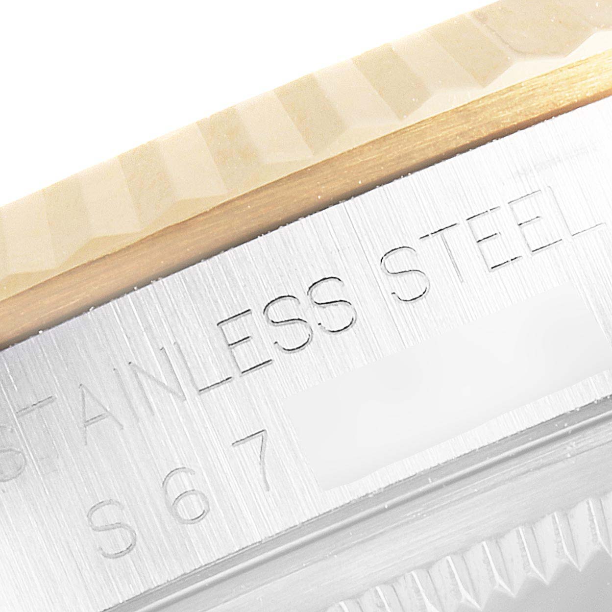 This image shows a close-up of the bezel and casing of a Rolex Datejust 16233G Men's Steel and Gold (two tone) Champagne Dial 16233G Men's Steel and Gold (two tone) Champagne Dial watch, highlighting the stainless steel inscription.