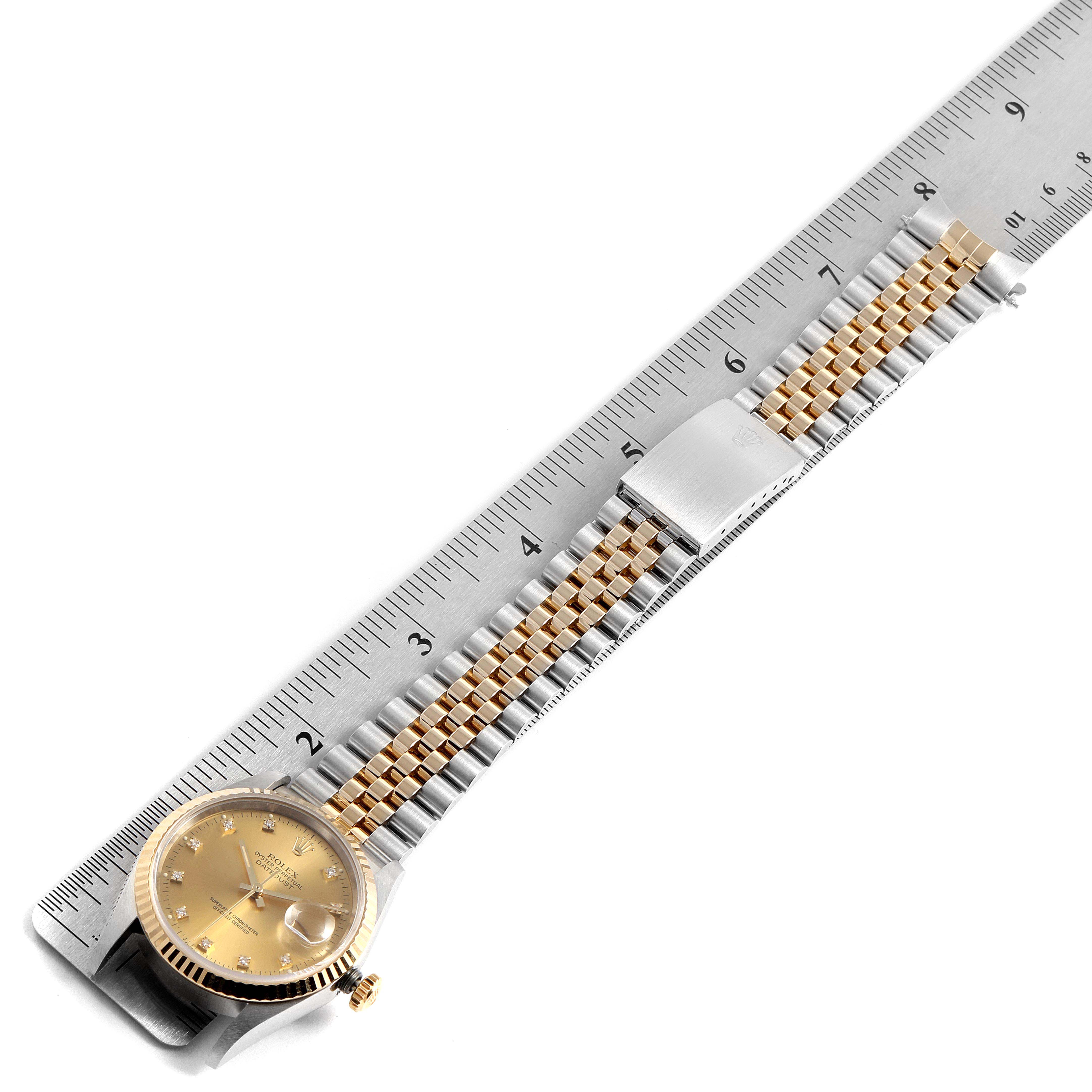 The Rolex Datejust 16233G Men's Steel and Gold (two tone) Champagne Dial 16233G Men's Steel and Gold (two tone) Champagne Dial watch is shown from a top view against a ruler, showcasing its dial and metal bracelet.