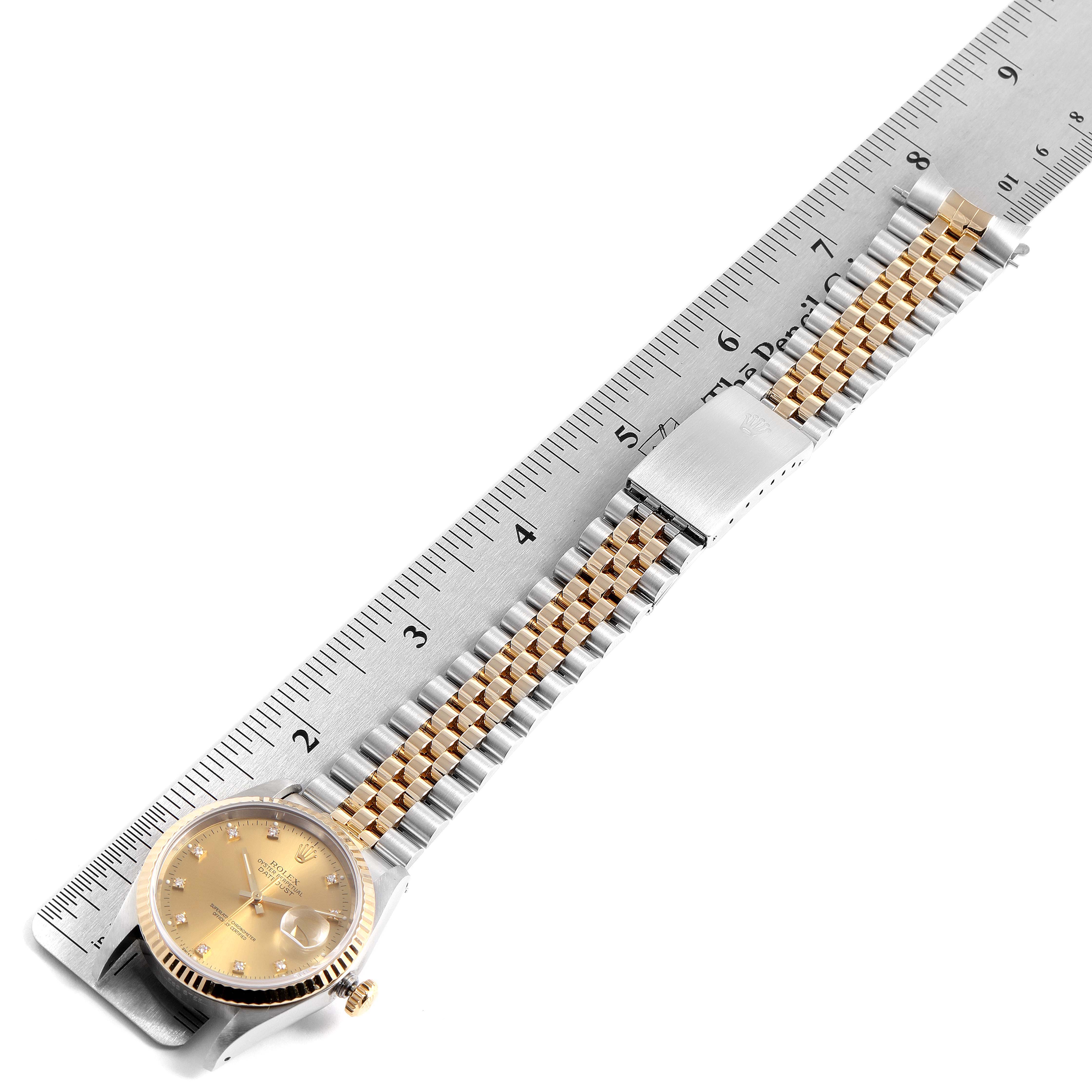 The Rolex Datejust 16233 Men
s Steel and Gold (two tone) Champagne Dial 16233 Men
s Steel and Gold (two tone) Champagne Dial watch is shown laying flat with its face, bezel, bracelet, and clasp visible against a ruler for scale.