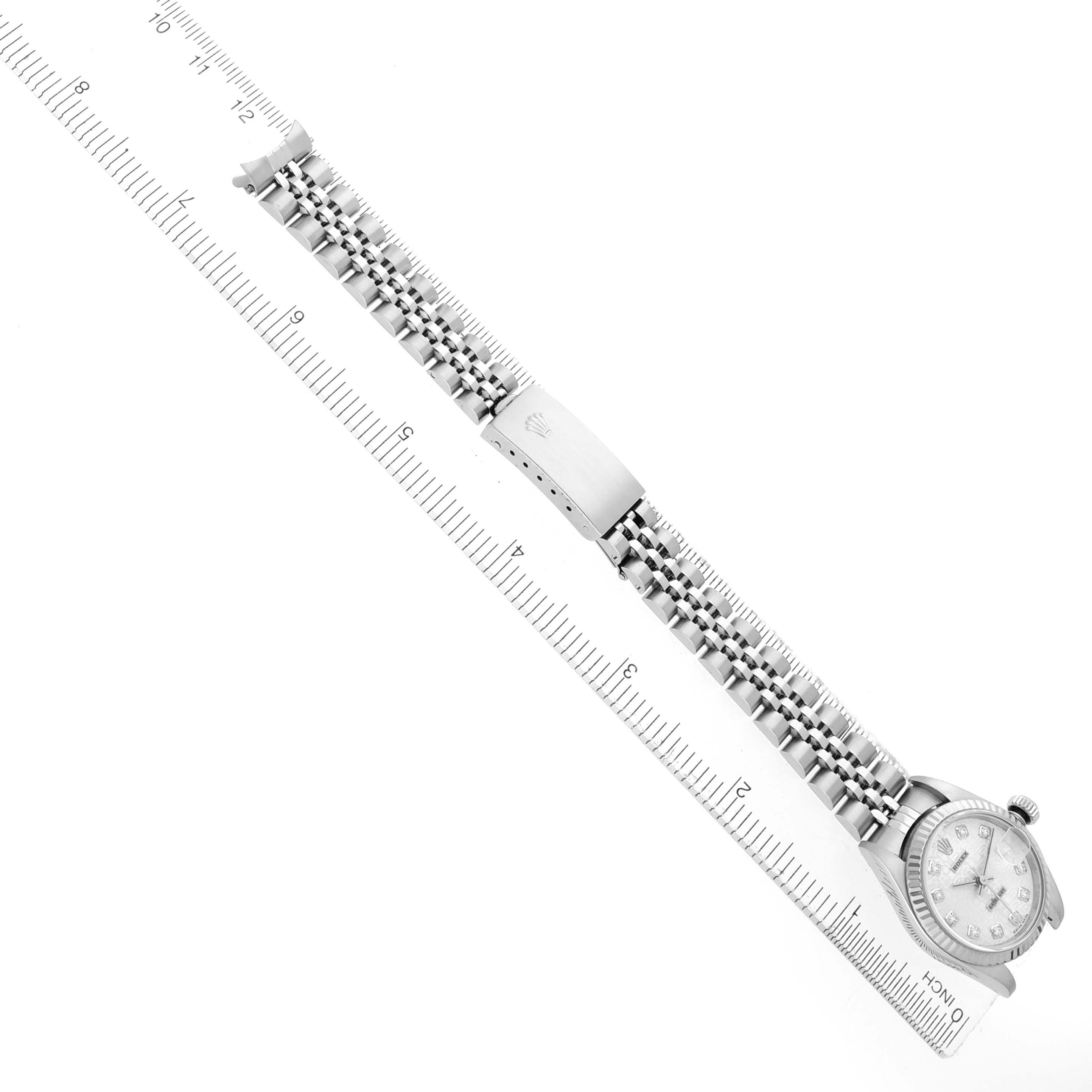 The Rolex Datejust 79174 Women's Stainless Steel Silver Dial watch is shown from the top view, displaying the entire bracelet and clasp alongside a measuring ruler.