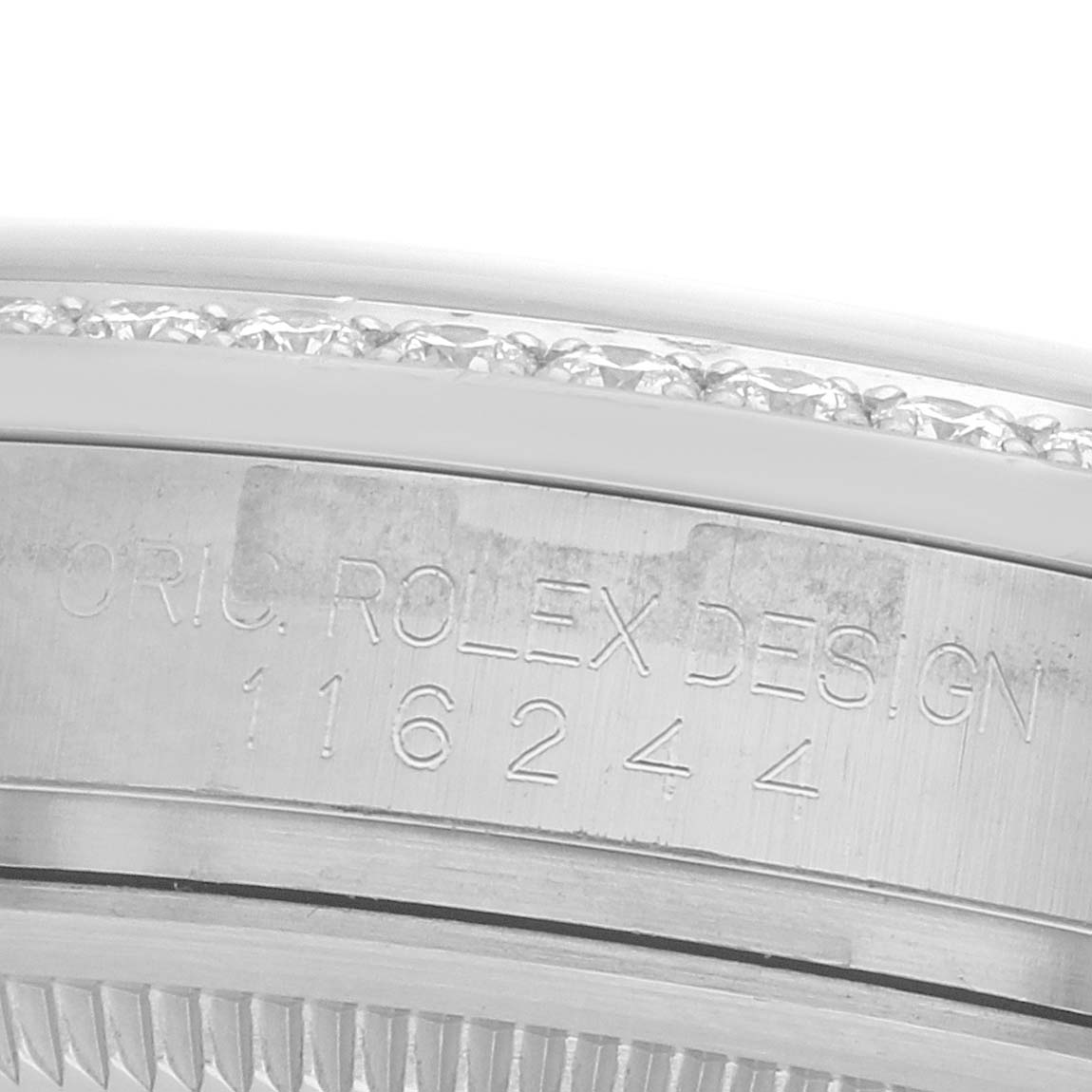 The image shows a close-up of the Rolex Datejust 116244 Men
s Stainless Steel Mother of Pearl Dial model
s case side, featuring engravings and a portion of the bezel adorned with diamonds.