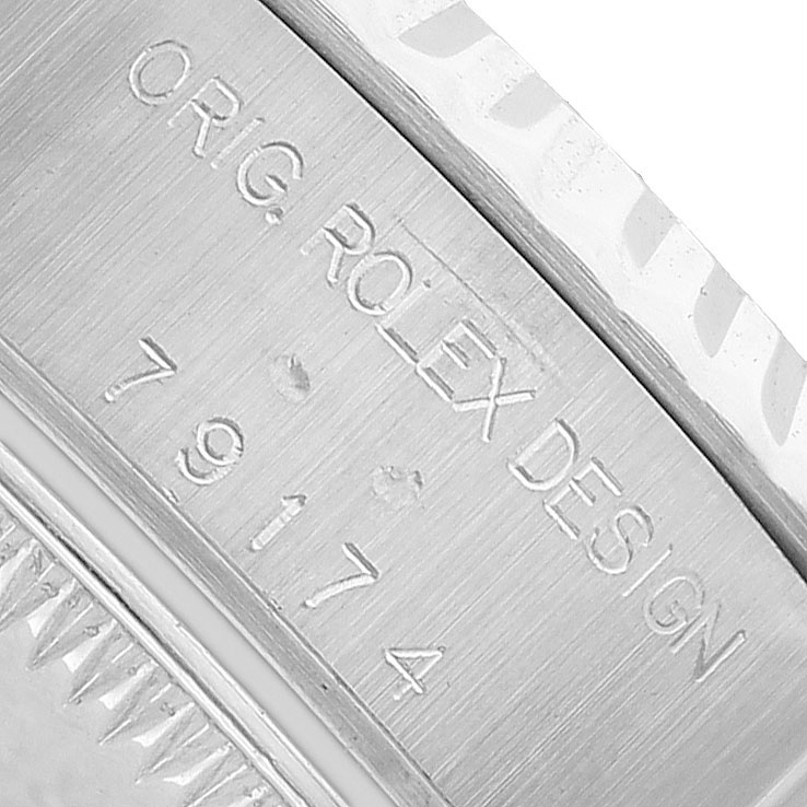 The image shows a close-up of the Rolex Datejust 79174 Women's Stainless Steel Mother of Pearl Dial's watch case with engraved model and serial numbers.