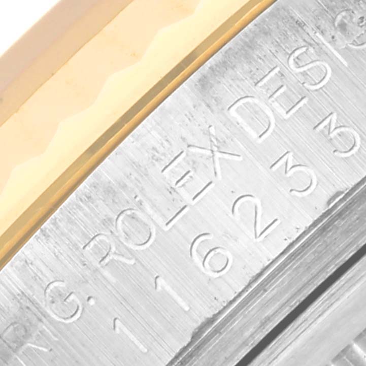 This close-up image shows the engraved bezel of a Rolex Datejust 116233 Men
s Steel and Gold (two tone) Champagne Dial 116233 Men
s Steel and Gold (two tone) Champagne Dial watch.