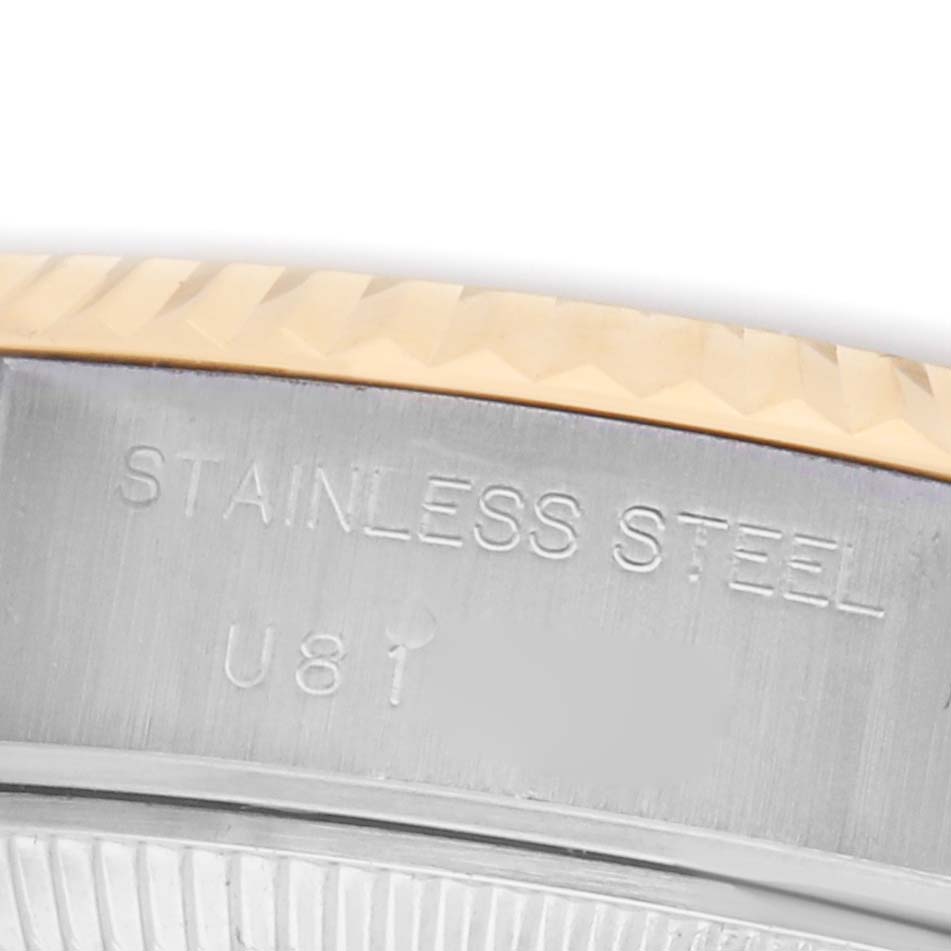 The image shows a close-up of the stainless steel case side and gold-edged bezel of a Rolex Datejust 69173 Women
s Steel and Gold (two tone) Champagne Dial watch.