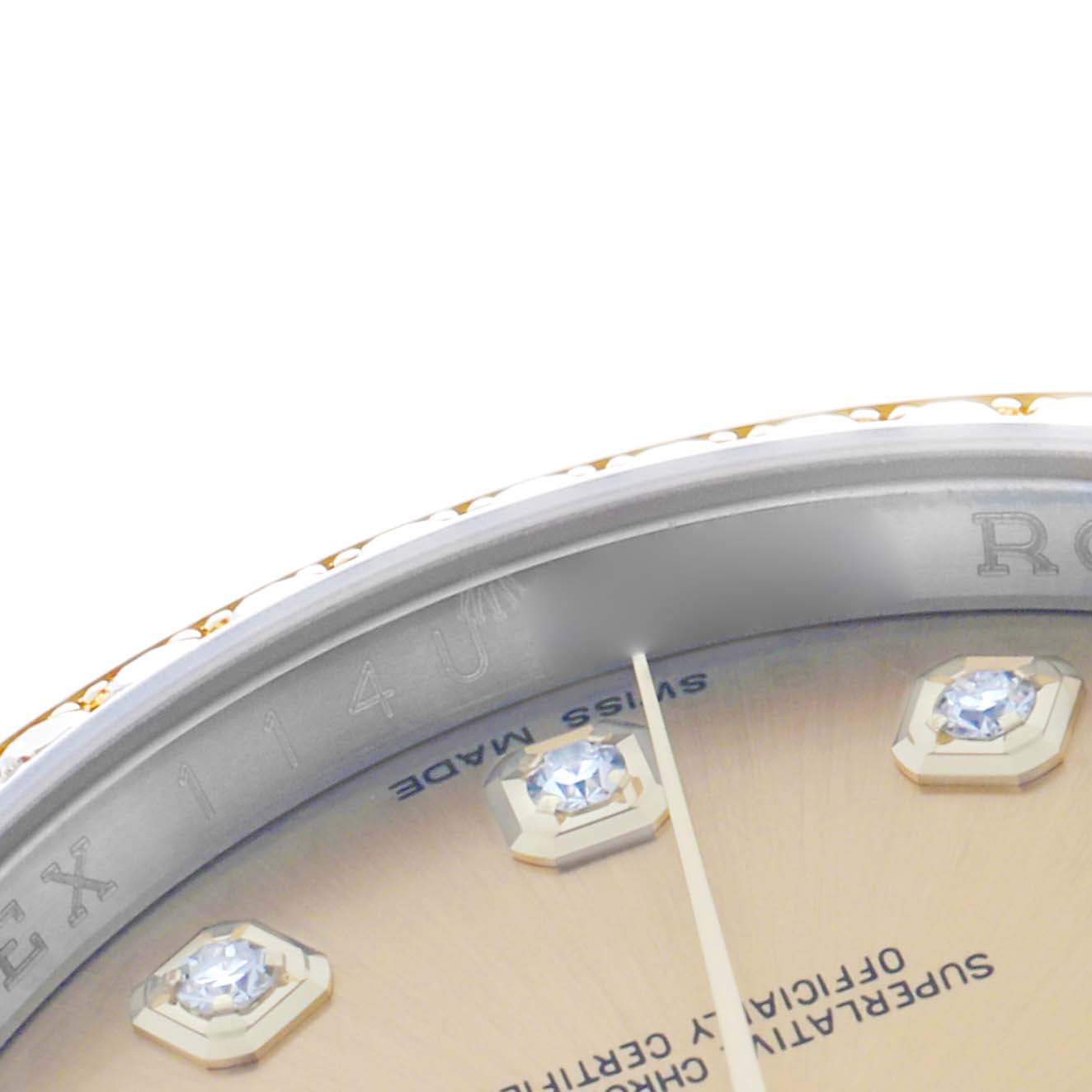 This close-up image of the Rolex Datejust 116243 Men
s Steel and Gold (two tone) Champagne Dial shows a partial view of the dial, including diamond markers and the engraved inner bezel.