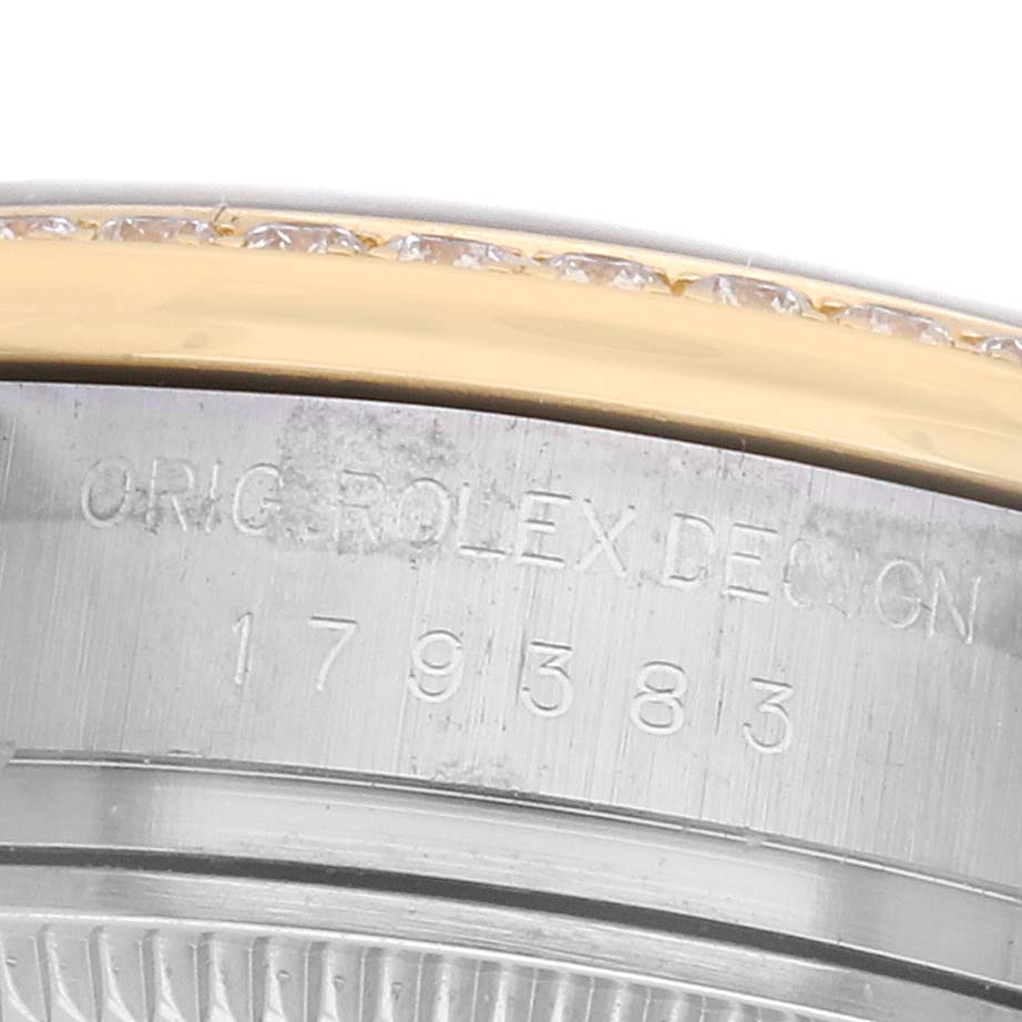 The image shows a close-up of the side of a Rolex Datejust 179383 Women's Steel and Gold (two tone) Black Dial watch, featuring the engraved serial number and bezel details.