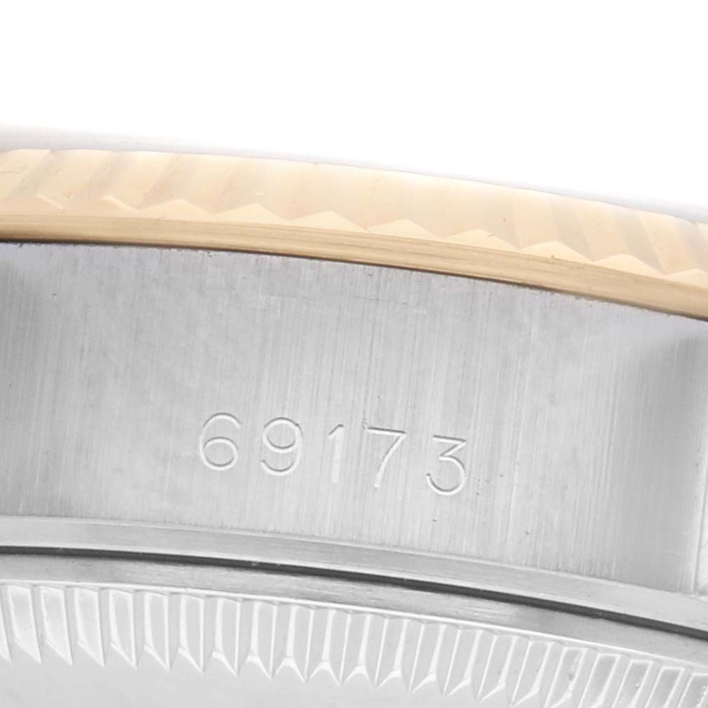 The image shows a partial side view of the Rolex Datejust 69173 Women's Steel and Gold (two tone) Champagne Dial, focusing on the case engraving and bezel.