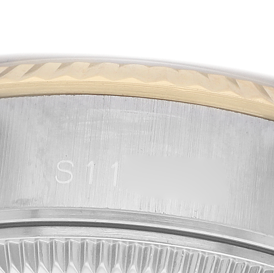 The image shows a close-up of the bezel and edge on a Rolex Datejust 69173 Women's Steel and Gold (two tone) Champagne Dial watch, highlighting the engraved serial area.