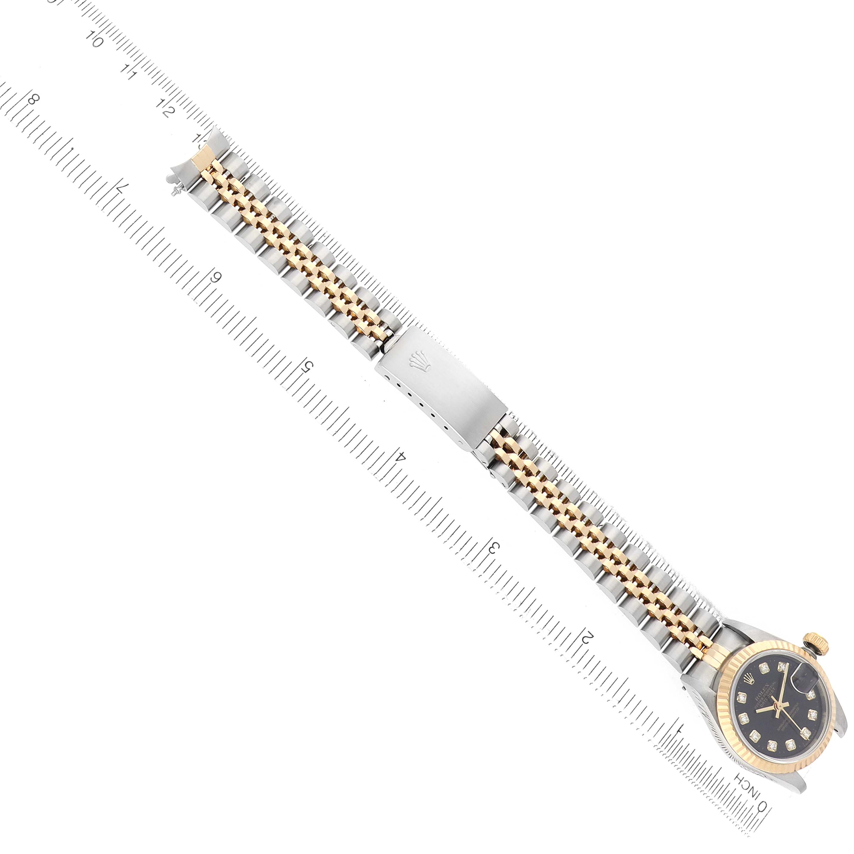 The Rolex Datejust 69173 Women
s Steel and Gold (two tone) Black Dial is shown from above with the bracelet fully extended and a ruler for scale.
