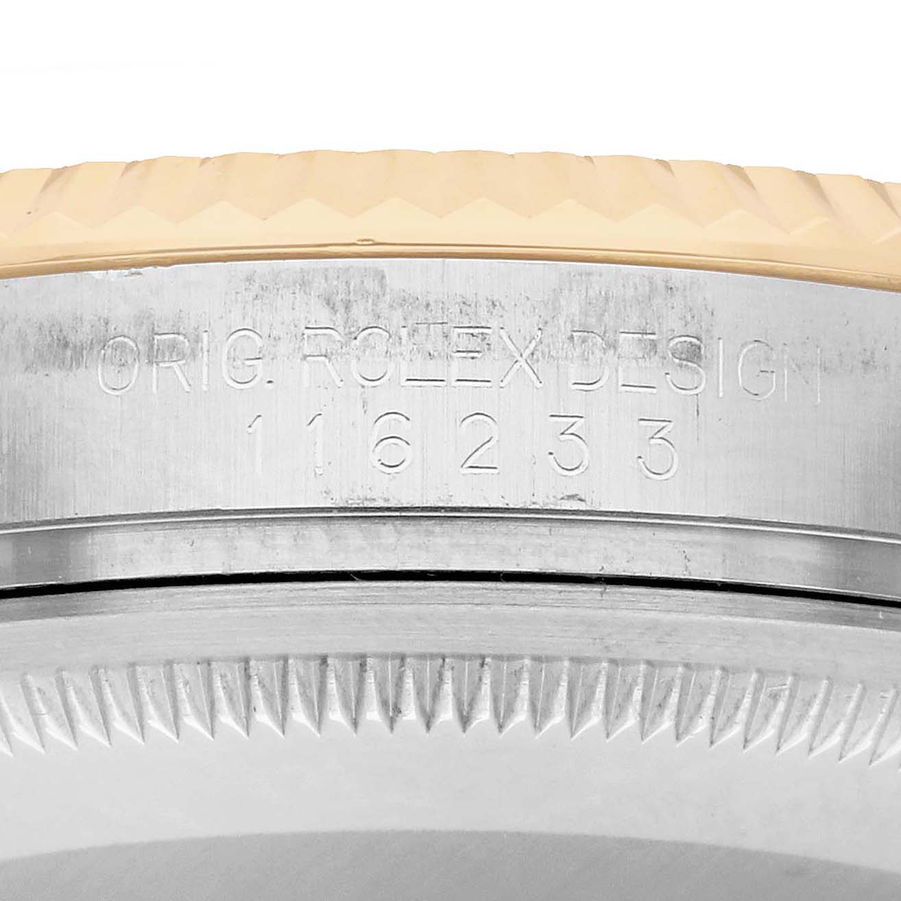 The image shows a close-up of the Rolex Datejust 116233 Men
s Steel and Gold (two tone) White Dial
s engraved case back edge and textured bezel.