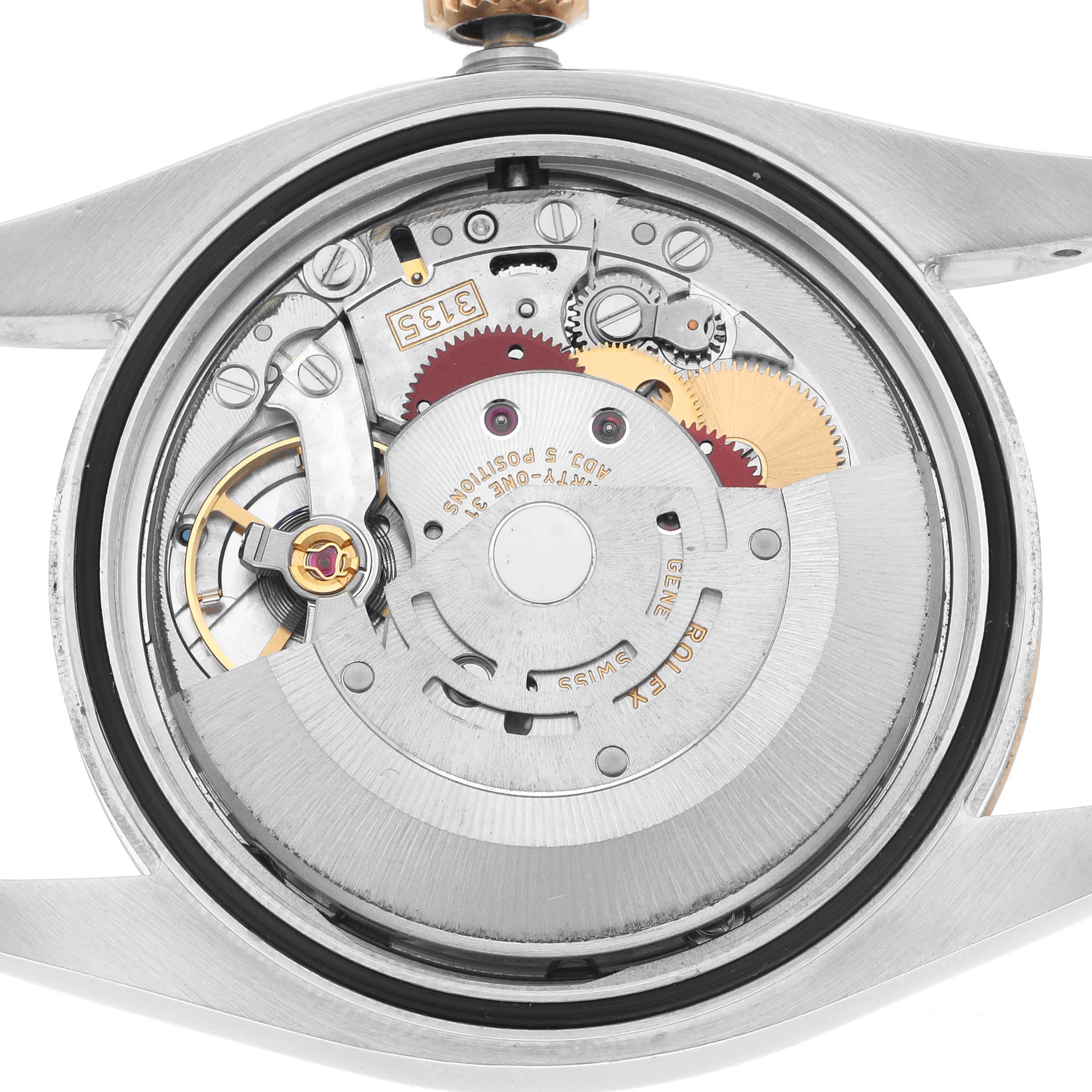 The image shows the internal movement of a Rolex Datejust 116233 Men
s Steel and Gold (two tone) White Dial watch from the back, highlighting gears and components.