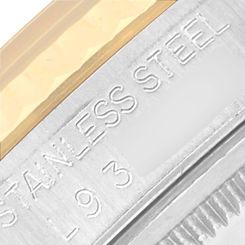 The image shows a close-up of the engraved edge detail on a Rolex Datejust 16233 Men
s Steel and Gold (two tone) Champagne Dial 16233 Men
s Steel and Gold (two tone) Champagne Dial watch, highlighting the "STAINLESS STEEL" text.