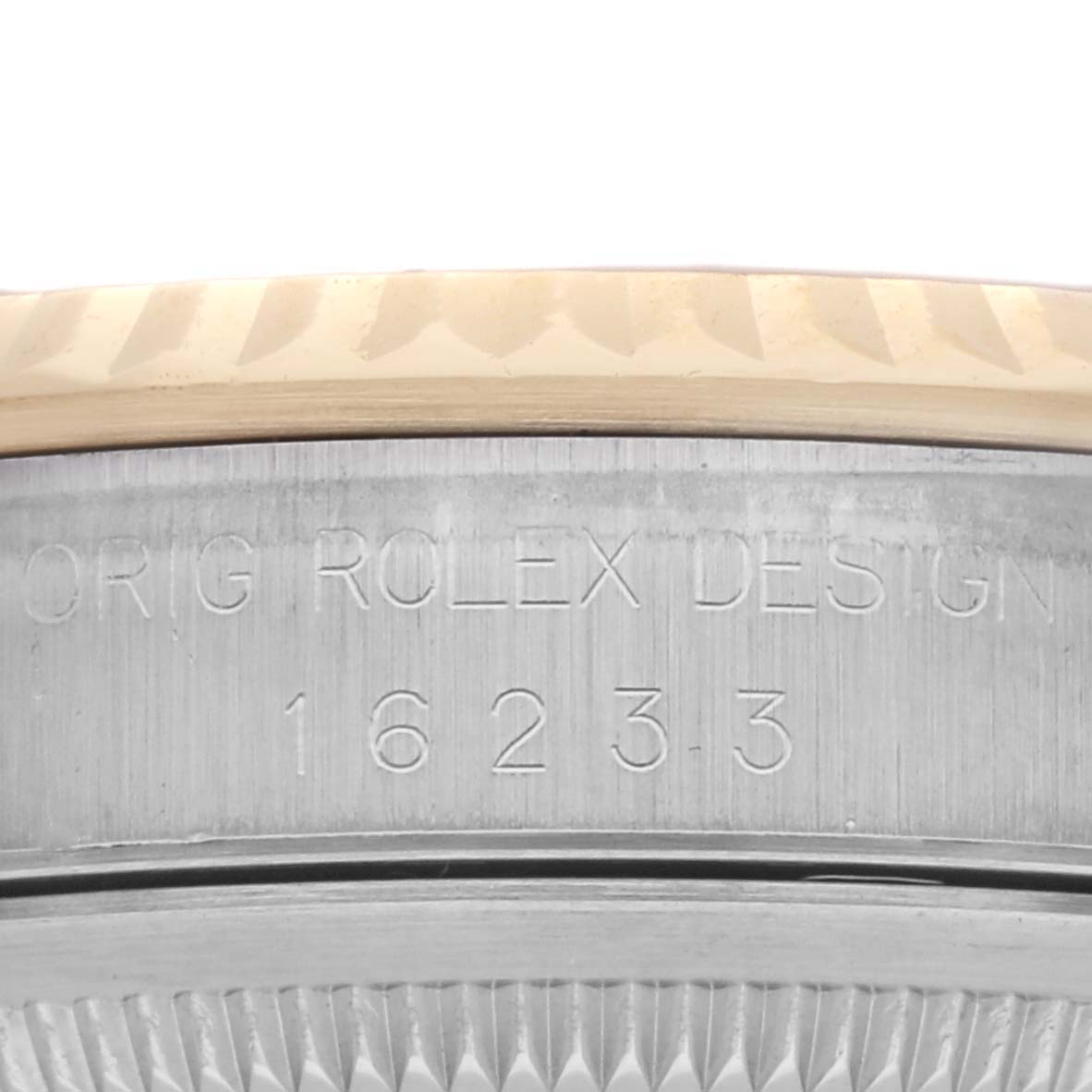The image shows the side engraving and fluted bezel of a Rolex Datejust 16233 Men's Steel and Gold (two tone) Champagne Dial 16233 Men's Steel and Gold (two tone) Champagne Dial watch.