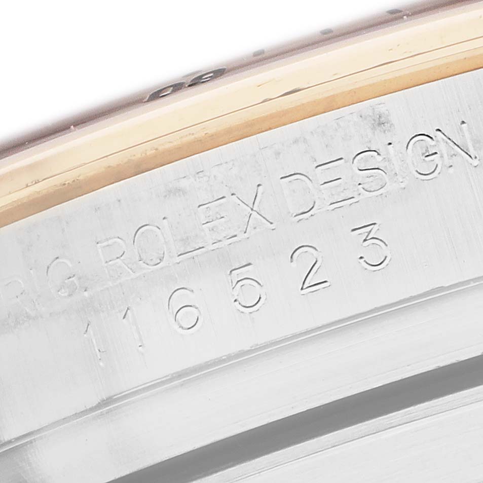This close-up angle shows the engraved model number and "Rolex Design" on the side of a Rolex Daytona 116523 Men
s Steel and Gold (two tone) Black Dial watch case.