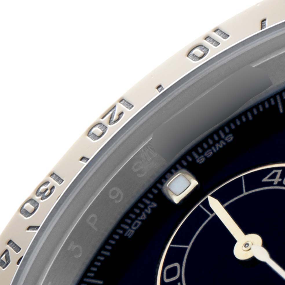 The image shows a close-up of the bezel and a portion of the dial from a Rolex Daytona 116523 Men
s Steel and Gold (two tone) Black Dial watch, highlighting the upper right section.