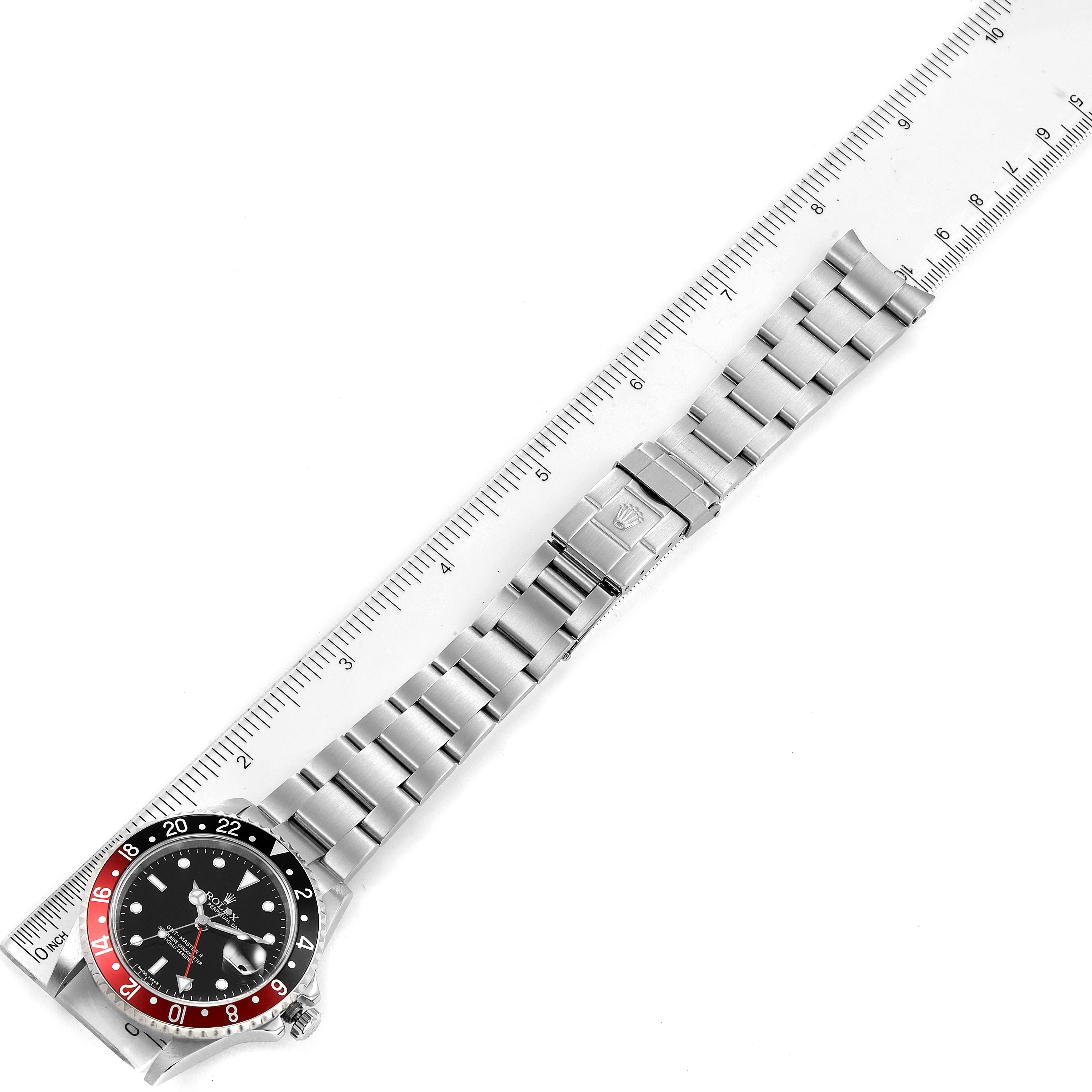 This image shows a top-down view of a Rolex GMT-Master 16710 Men's Stainless Steel Black Dial 16710 Men's Stainless Steel Black Dial watch, including the dial, bezel, bracelet, and clasp alongside a ruler for scale.