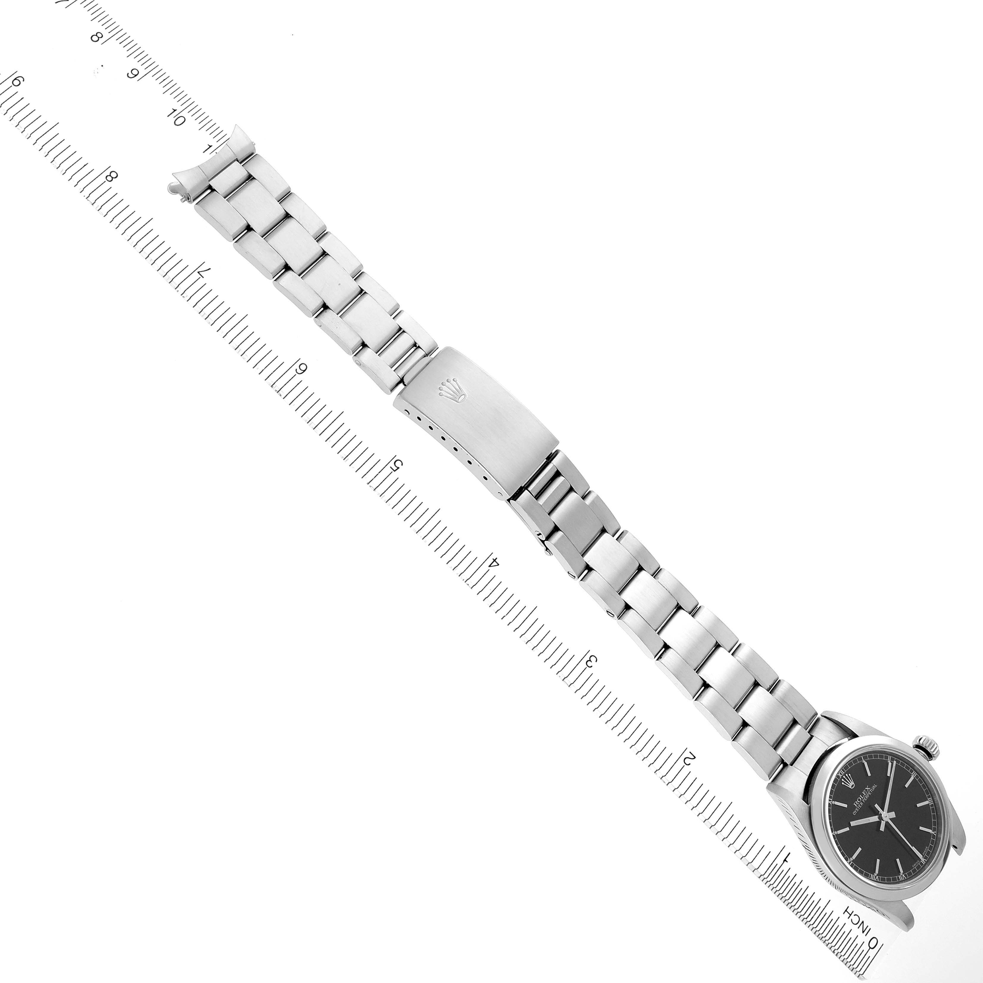 The image shows a Rolex Mid-Size 77080 Women's Stainless Steel Black Dial 77080 Women's Stainless Steel Black Dial watch laid flat, displaying its bracelet, clasp, and face alongside a ruler.