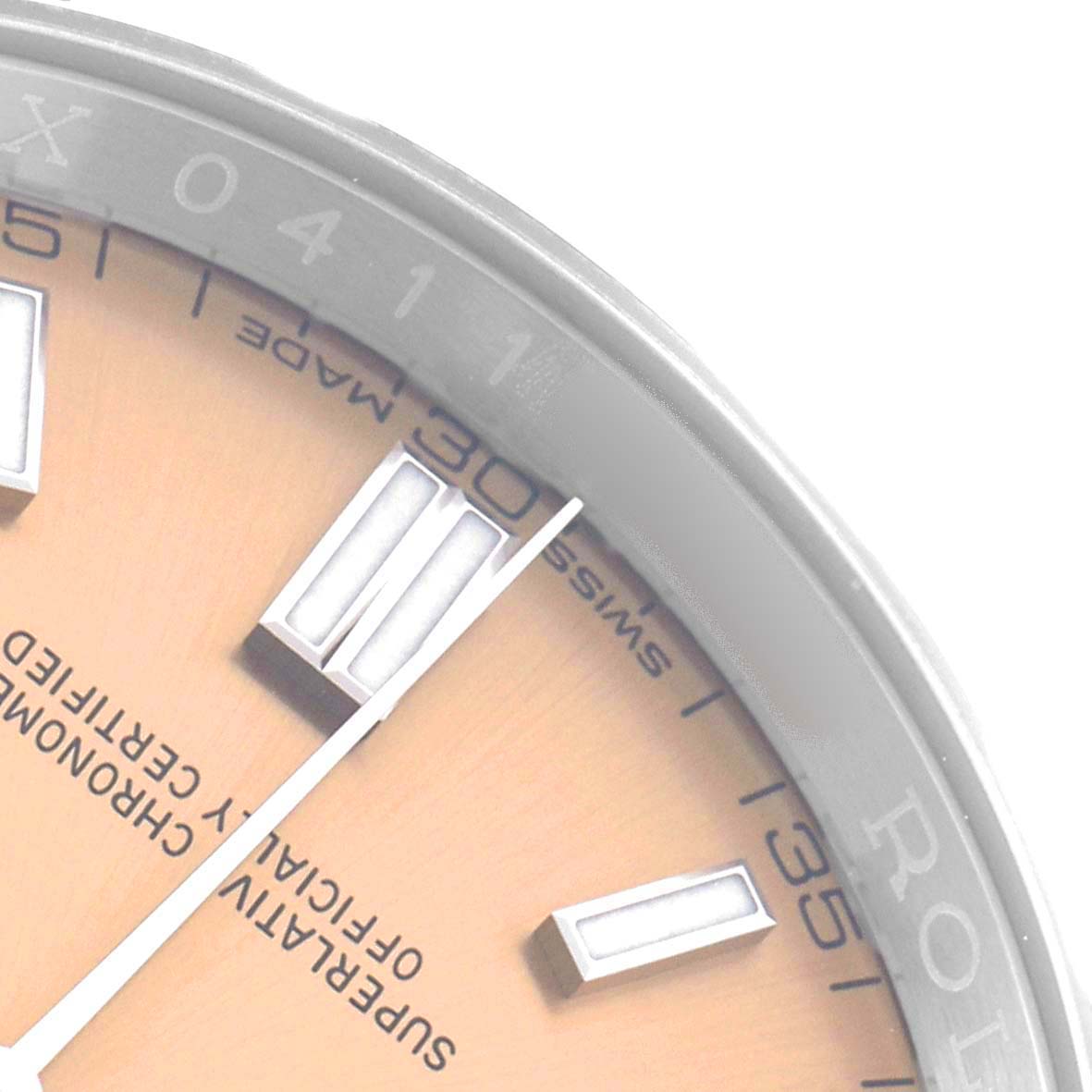 The image shows a close-up of the Rolex Oyster Perpetual 116000 Men
s Stainless Steel Champagne Dial watch face at an angle, highlighting the dial, markings, and part of the bezel.