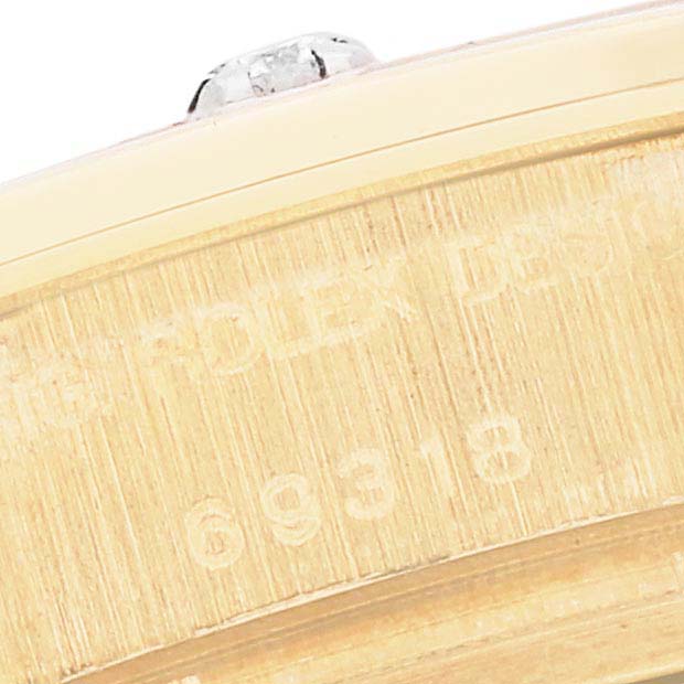 The image shows the side view of a Rolex Pearlmaster 69318 Women's Yellow Gold Champagne Dial 69318 Women's Yellow Gold Champagne Dial watch, focusing on the engraved case edge with the model number.