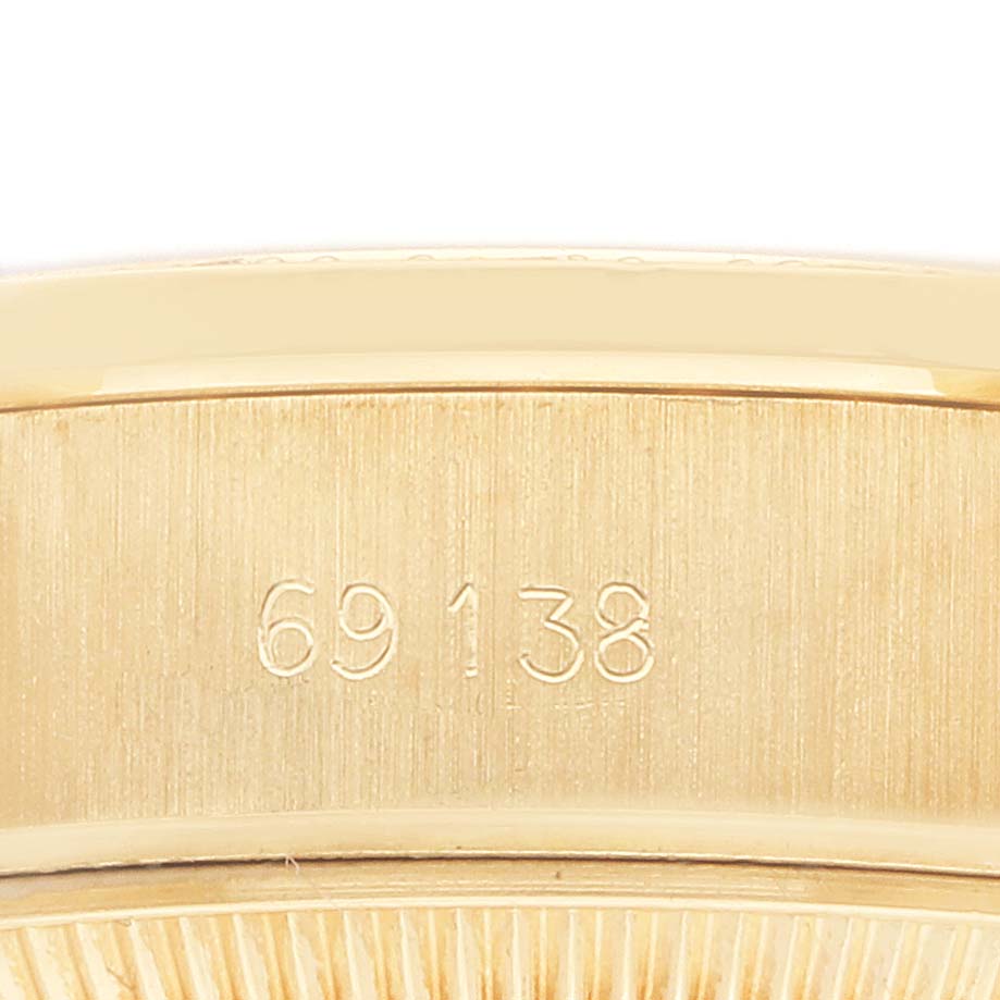 The image shows a close-up of the case back and serial number on the side of the Rolex President 69138 Women
s Yellow Gold Champagne Dial watch.