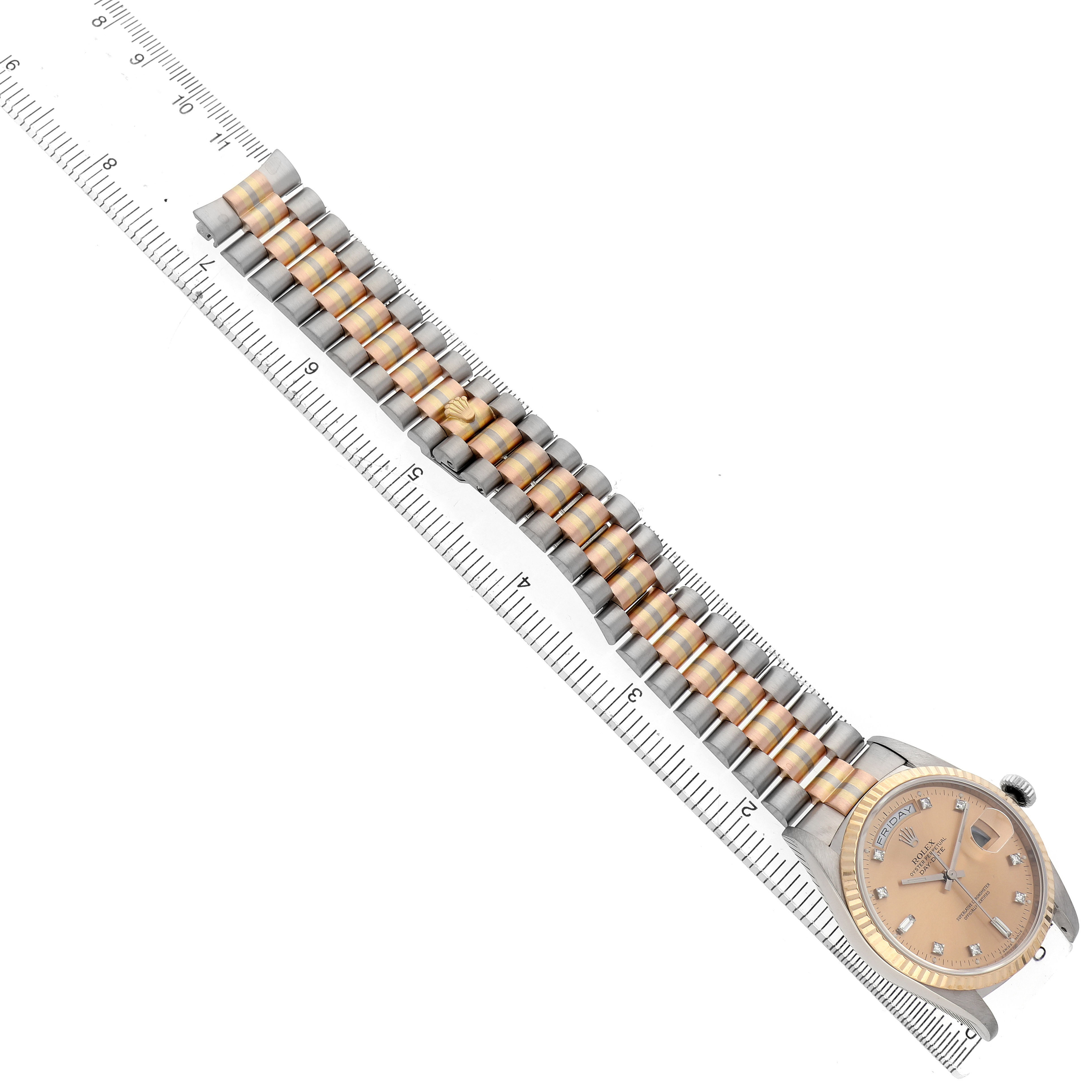 The image shows a Rolex President 18239B Men's White Gold Champagne Dial model watch laid flat, highlighting its strap and face alongside a measuring ruler for scale.