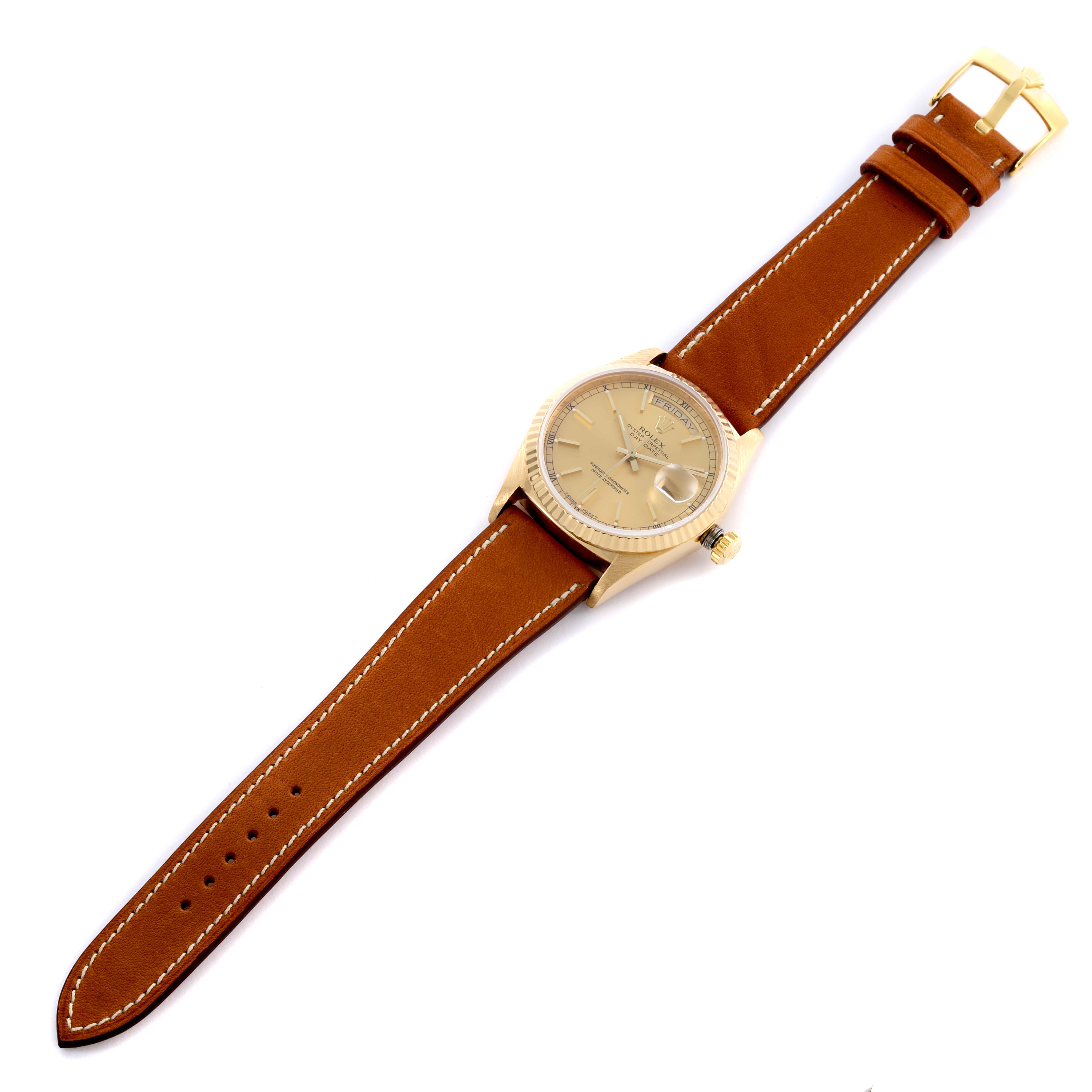 The Rolex President 18038 Men
s Yellow Gold Champagne Dial 18038 Men
s Yellow Gold Champagne Dial watch is shown from an overhead angle, featuring its gold case, dial, and brown leather strap.