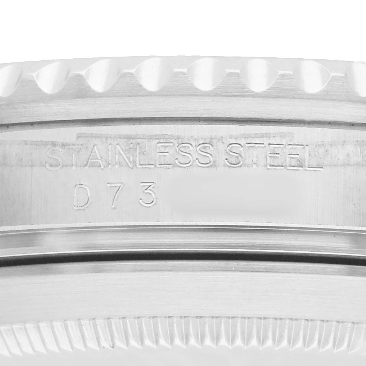 The image shows a close-up side view of the bezel and case edge of a Rolex Submariner 16610 Men
s Stainless Steel Black Dial, highlighting the "STAINLESS STEEL" engraving.