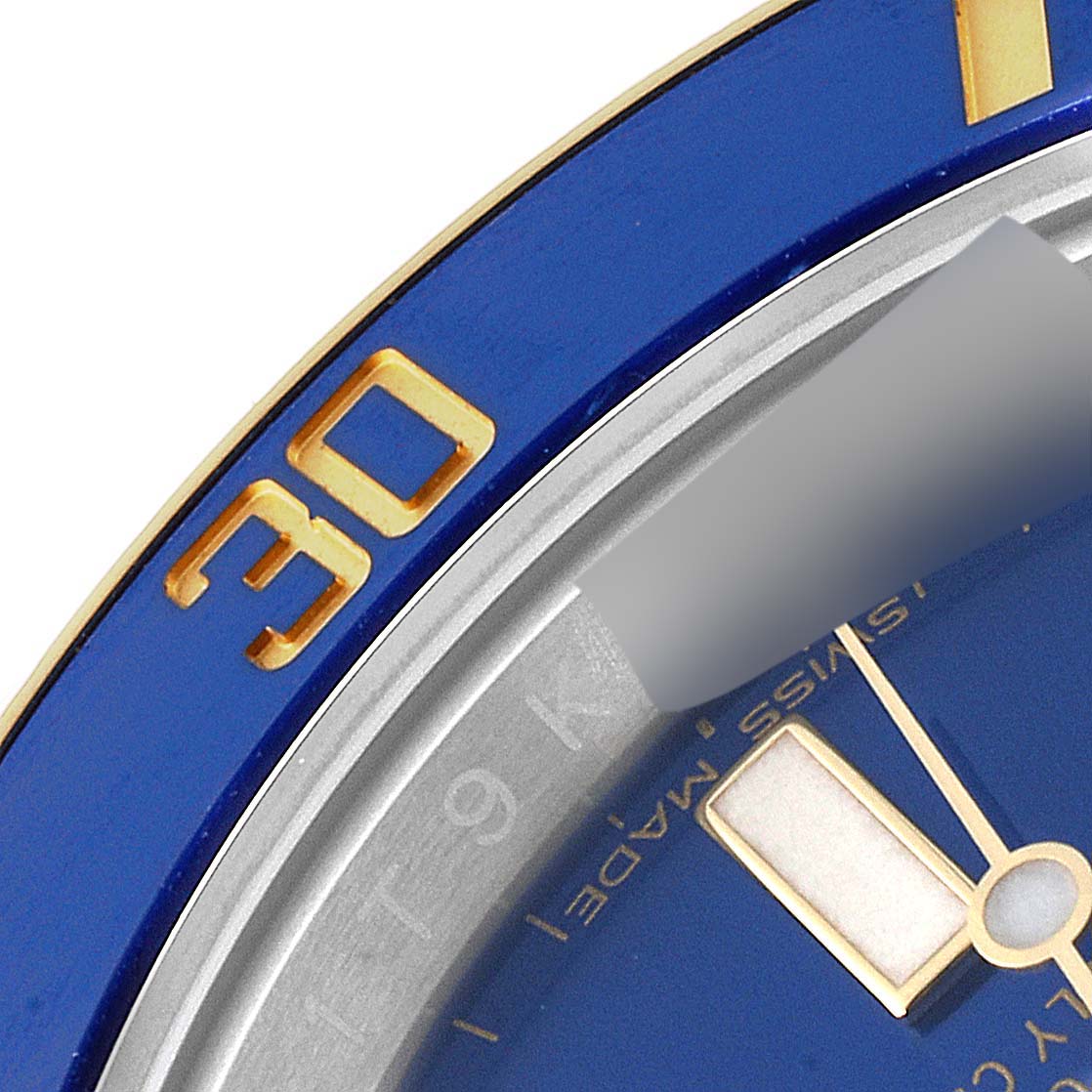 This close-up image of a Rolex Submariner 116613 Men's Steel and Gold (two tone) Blue Dial 116613 Men's Steel and Gold (two tone) Blue Dial watch shows part of the blue bezel, the "30" mark, and part of the dial with Swiss markings.
